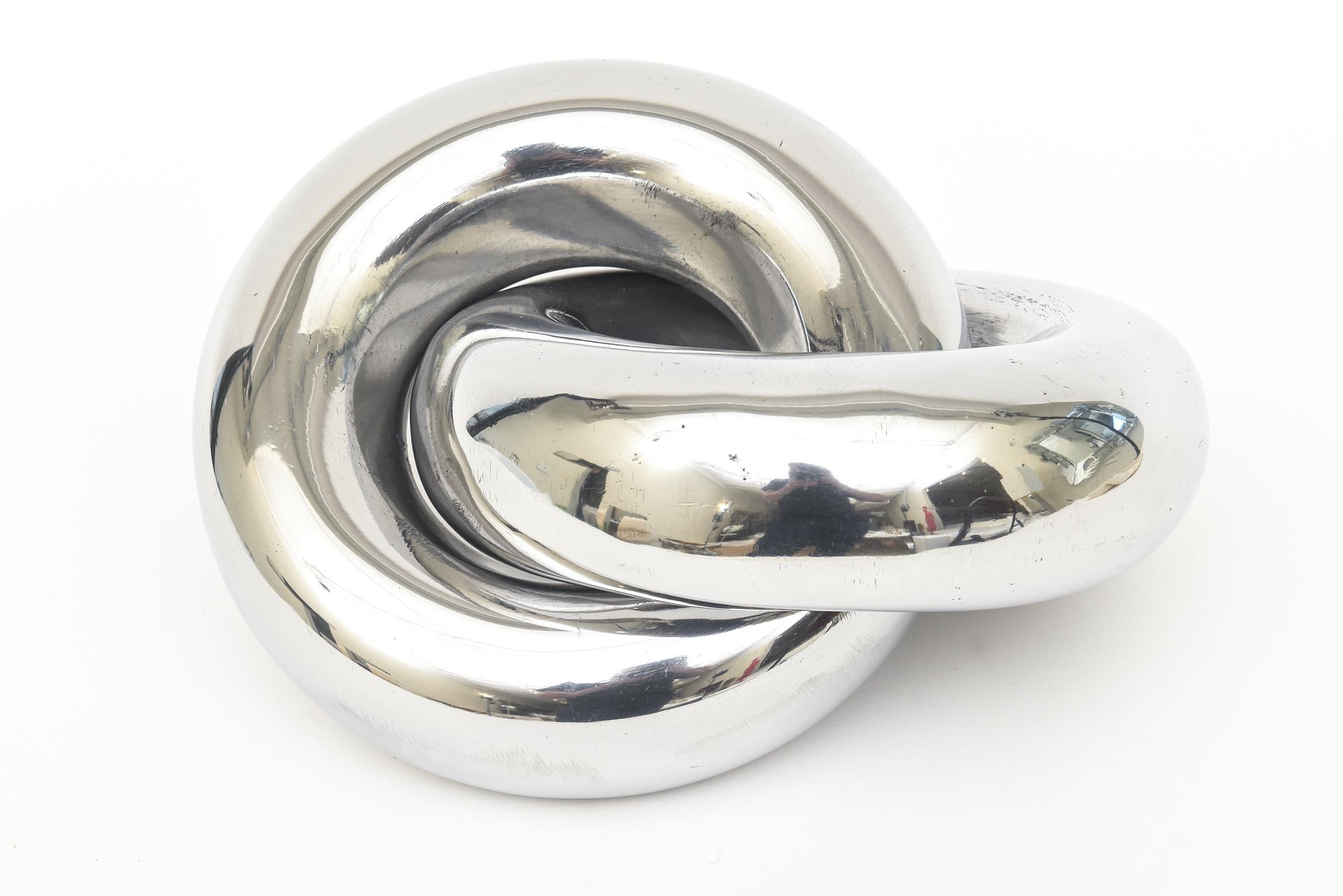 This authentic twisted intertwined polished aluminum intertwined ring sculpture is vintage from the 70's. It is NOT a reissue nor is it contemporary. It has been professionally polished carefully and makes a great statement sculpture. This one is