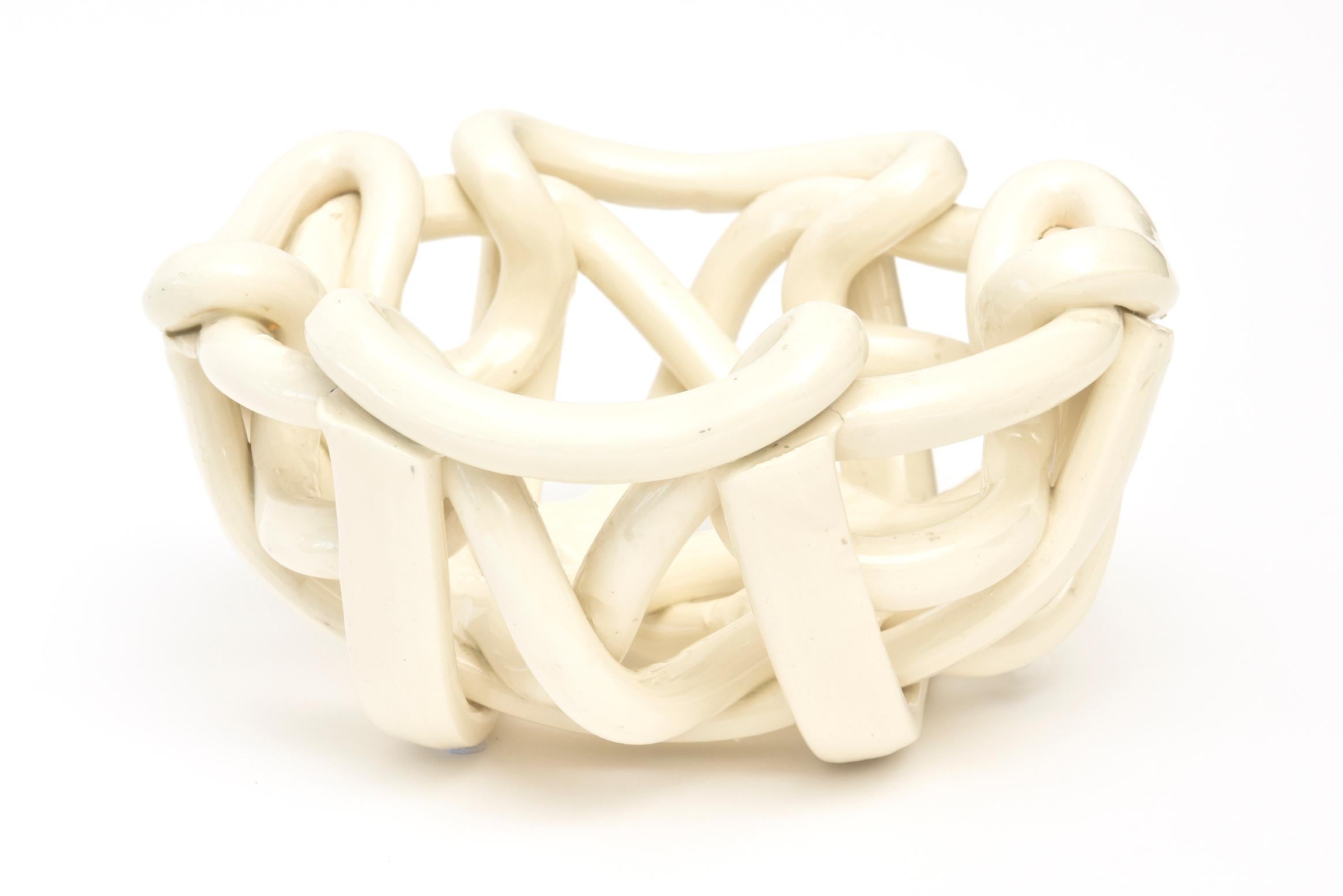 This sculptural twisted and coiled vintage ceramic bowl is from the 1970s. It is American yet looks Italian. The color is an off-white hue. It is one long twisted piece of ceramic coiled in sculptural form. This can be used for utilitarian purposes