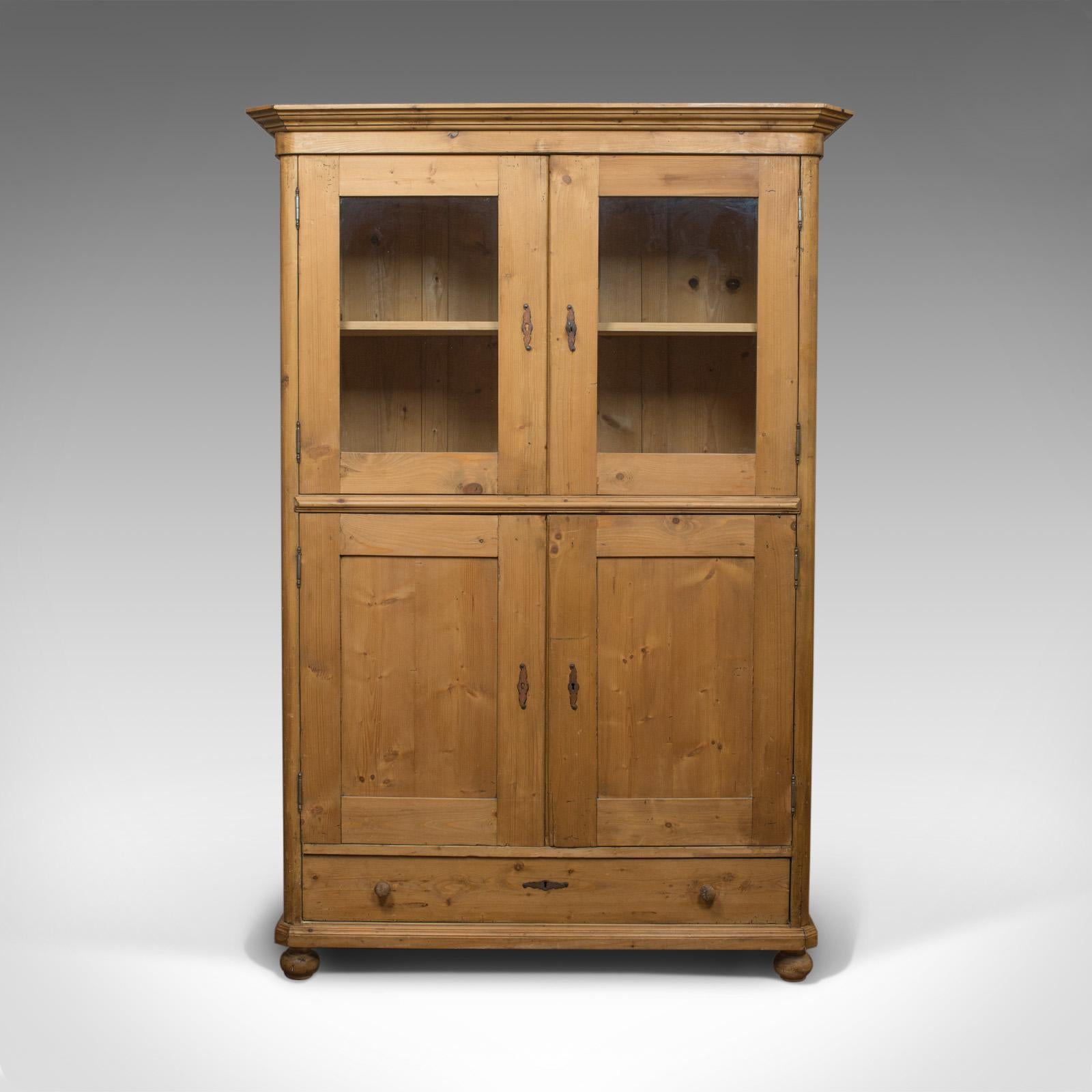 This is a vintage two-door bookcase cabinet. A French, pine cupboard dating to the mid-20th century, circa 1960.

Select pine displays rich biscuit hues and fine grain interest
Good consistent color throughout and a desirable aged patina
Deep