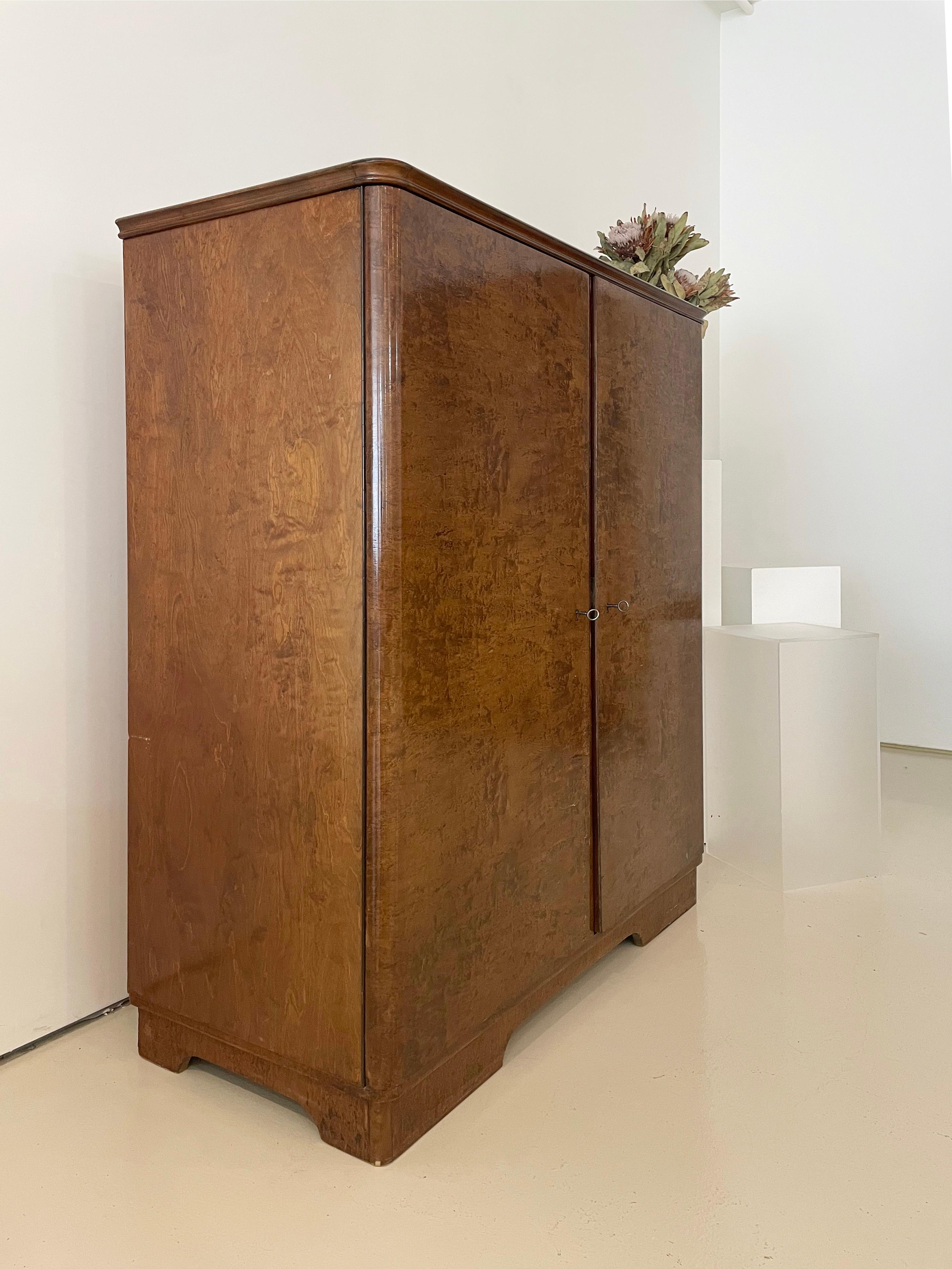 Armoire vintage unique, fabriquée sur mesure dans un style Art Deco

Portes et côtés plaqués de ronce d'érable, teintés dans un riche ton de noyer. 

Beaux côtés incurvés et moulures 

Tiroirs et étagères intérieurs en forme de plateau.

Chaque