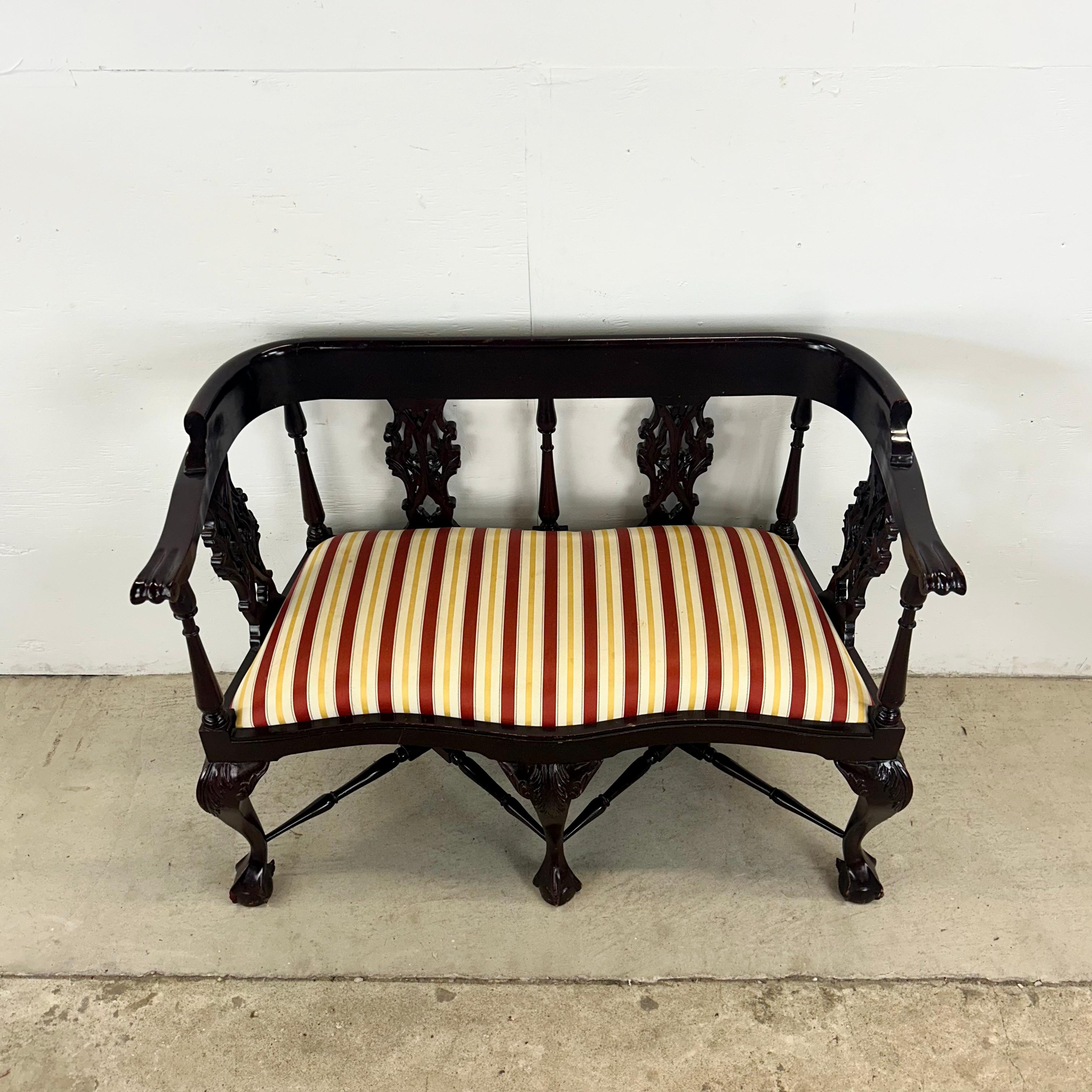Ce remarquable canapé à deux places reflète l'élégance et le savoir-faire du design Chippendale classique. Façonné dans un riche acajou foncé, le cadre présente des détails magnifiquement sculptés, notamment des pieds en forme de boule et de griffe,