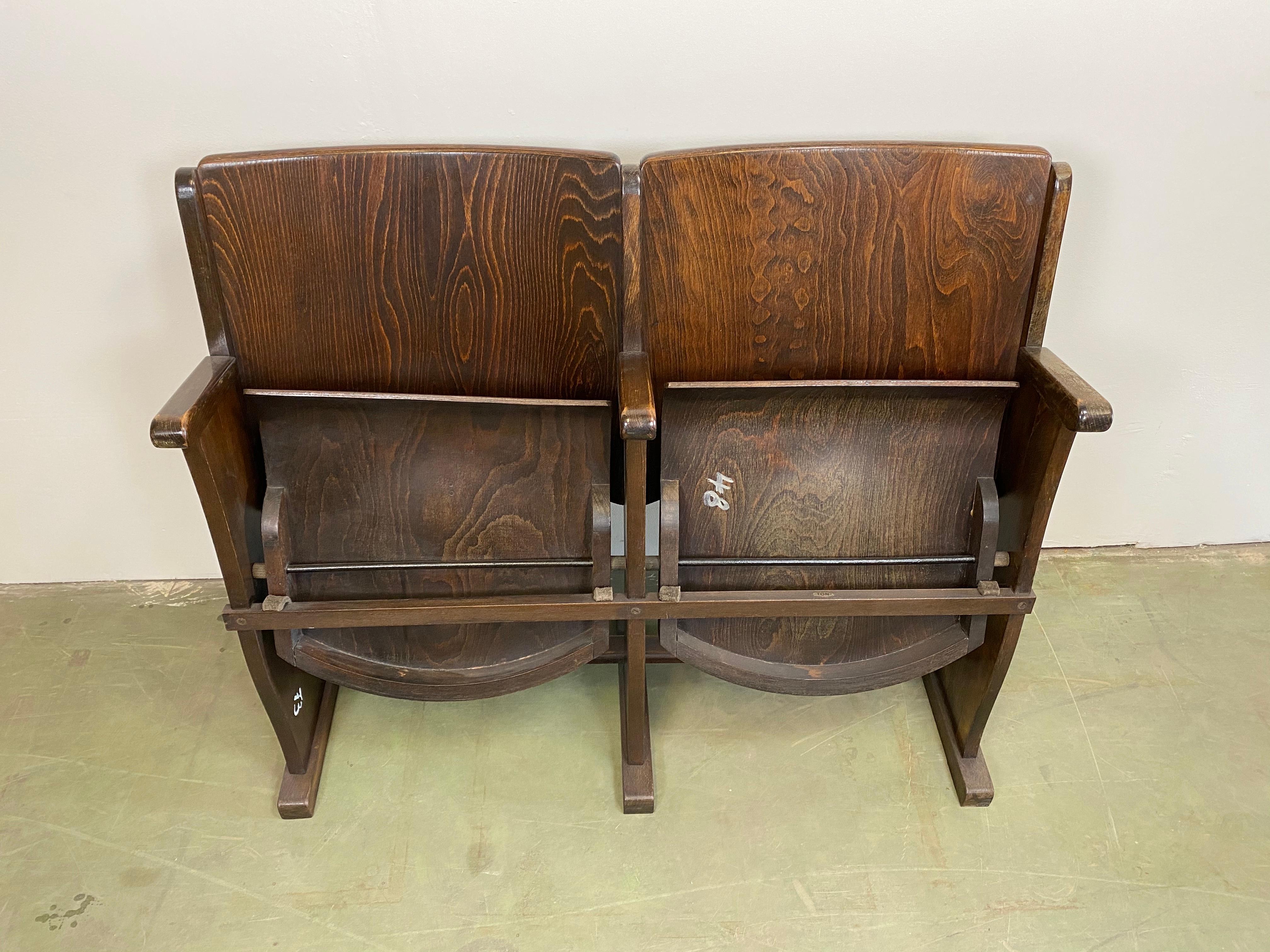 This two-seat cinema bench was produced by Ton (former Thonet) in Czechoslovakia during the 1950s. The chairs are stabile and can be placed anywhere. It is completely made of wood (partly solid wood, partly plywood). The seats fold upwards. The