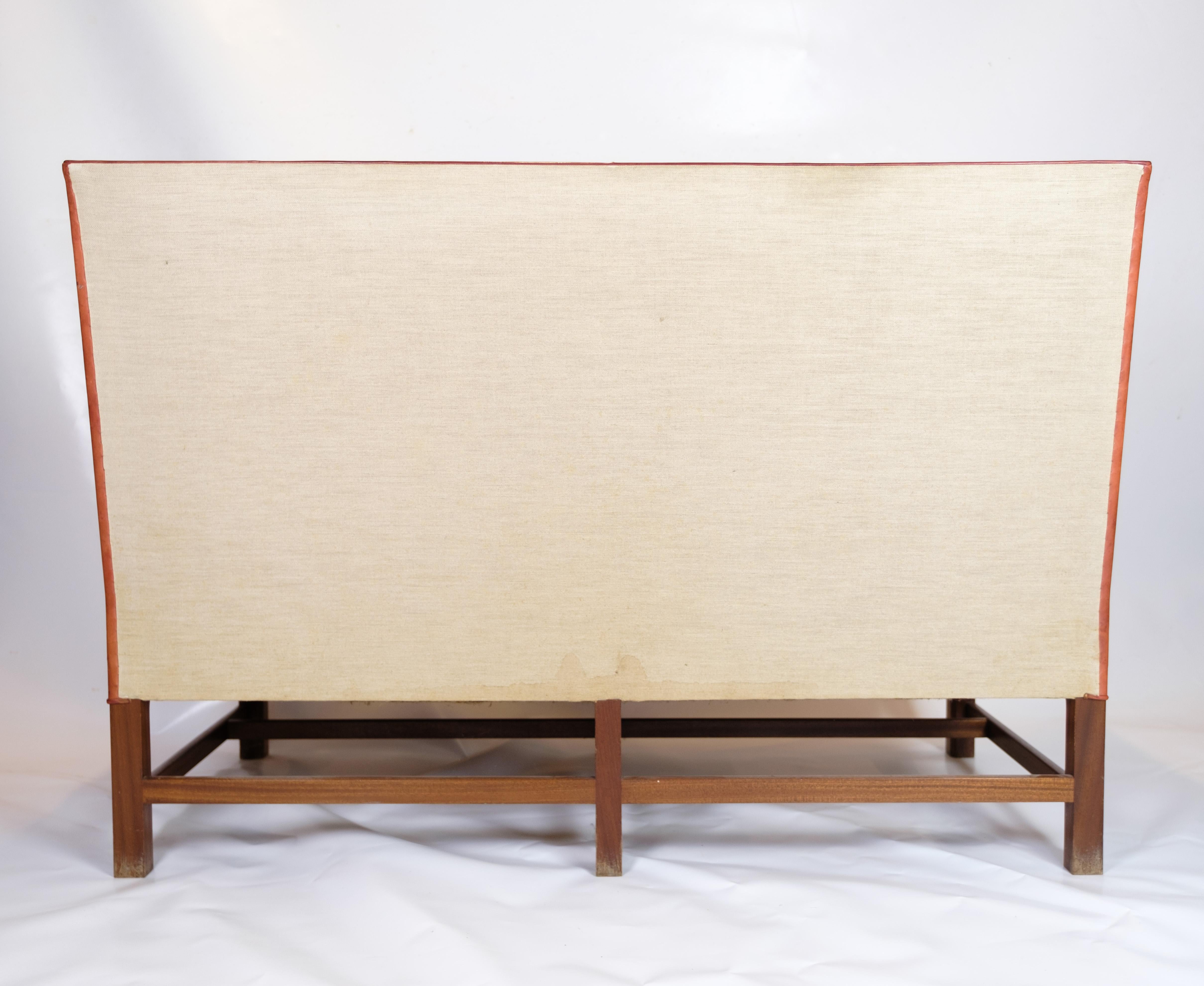 Le canapé deux places design vintage modèle 5011 créé par Kaare Klint. Cette pièce emblématique est fabriquée en cuir cognac d'origine et présente une base distinctive à six pieds en acajou. Le canapé a été reconnu après avoir été présenté à