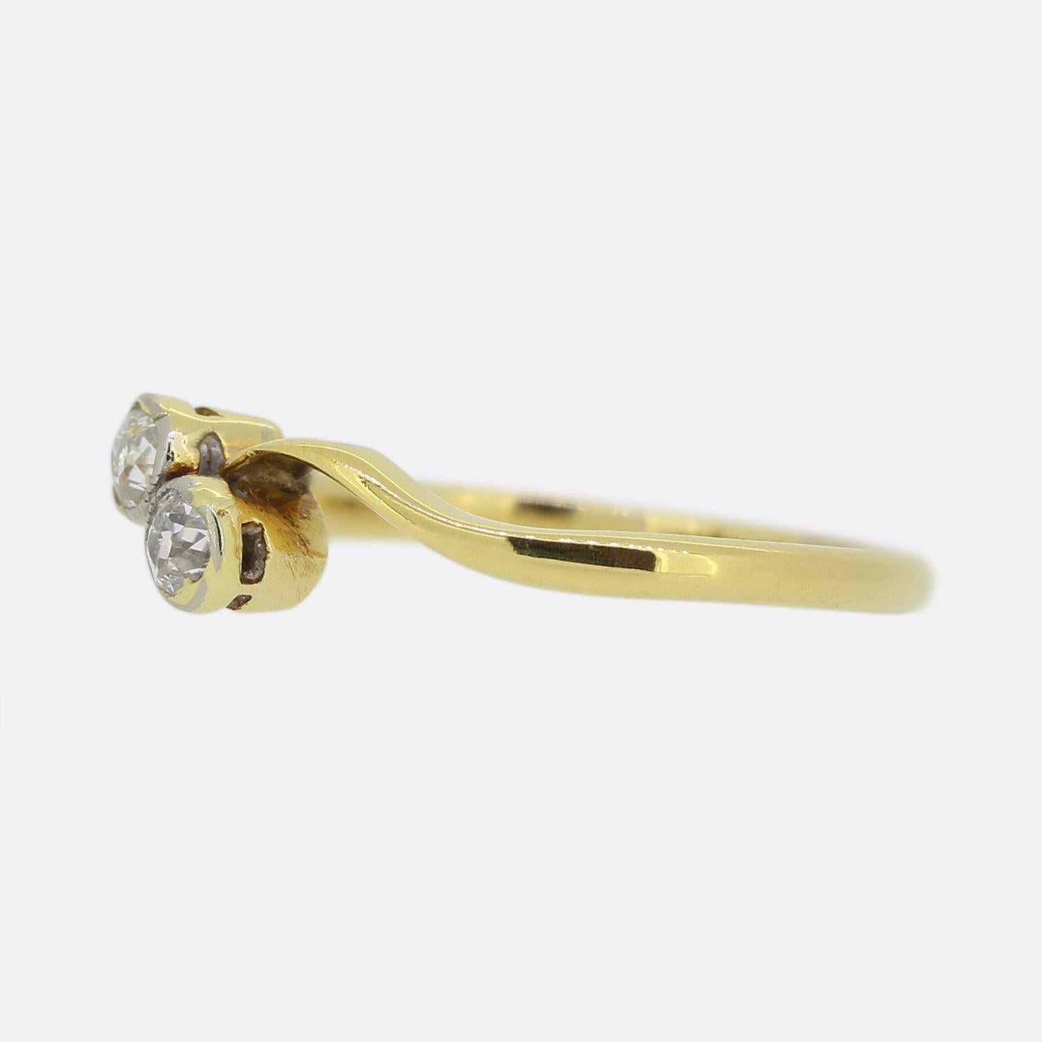 Here we have a classic two stone diamond ring. This vintage piece has been crafted from 18ct yellow gold and presents two closely rub-over set round old cut diamonds atop a thin swirling band. 

Condition: Used (Very Good)
Weight: 2.1 grams
Ring