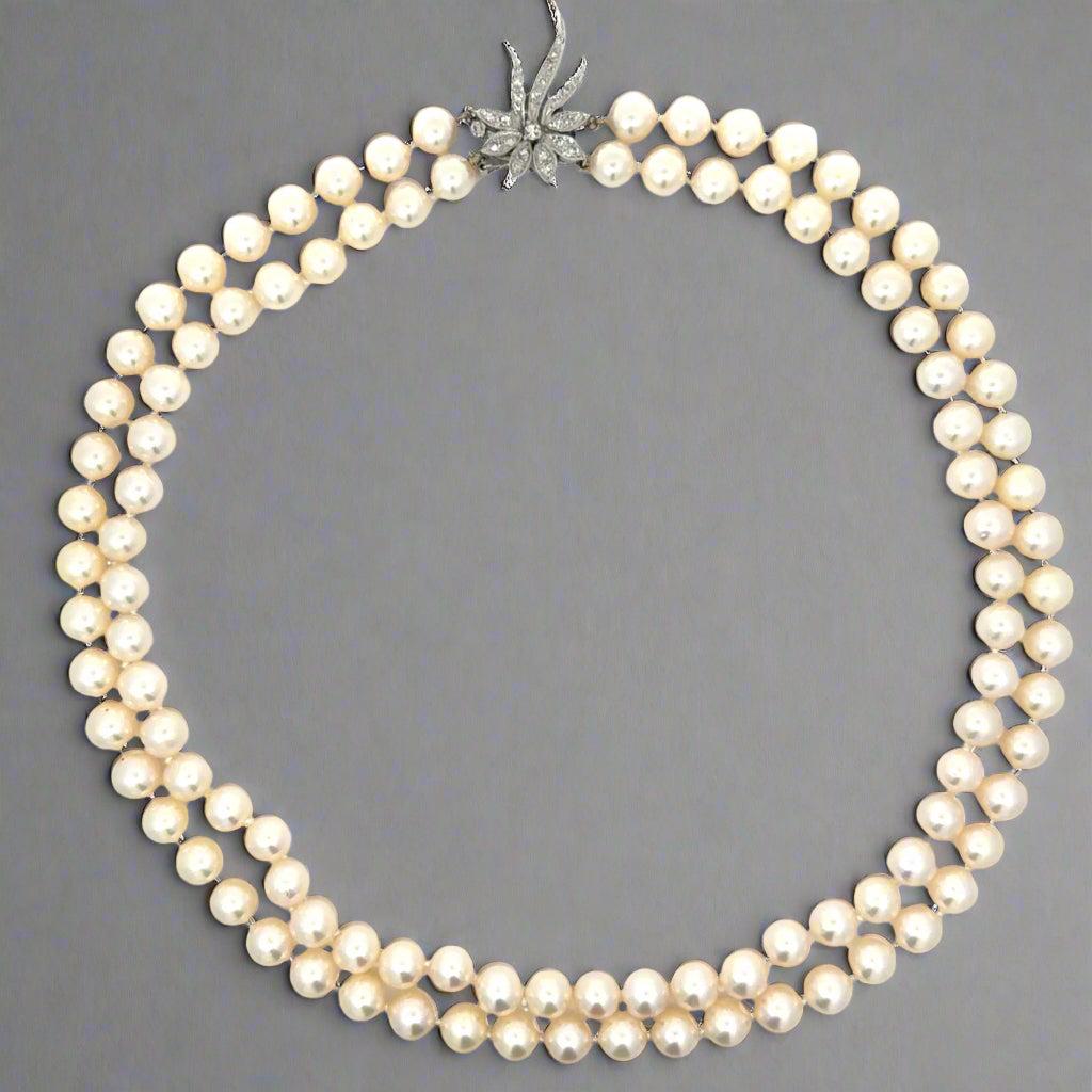 Elevate your collection with this Vintage Two Strand Japanese Akoya Pearl Necklace, featuring exceptionally fine-quality pearls renowned for their lustrous sheen and smooth surface. The necklace is elegantly secured by a stunning 14K gold flower