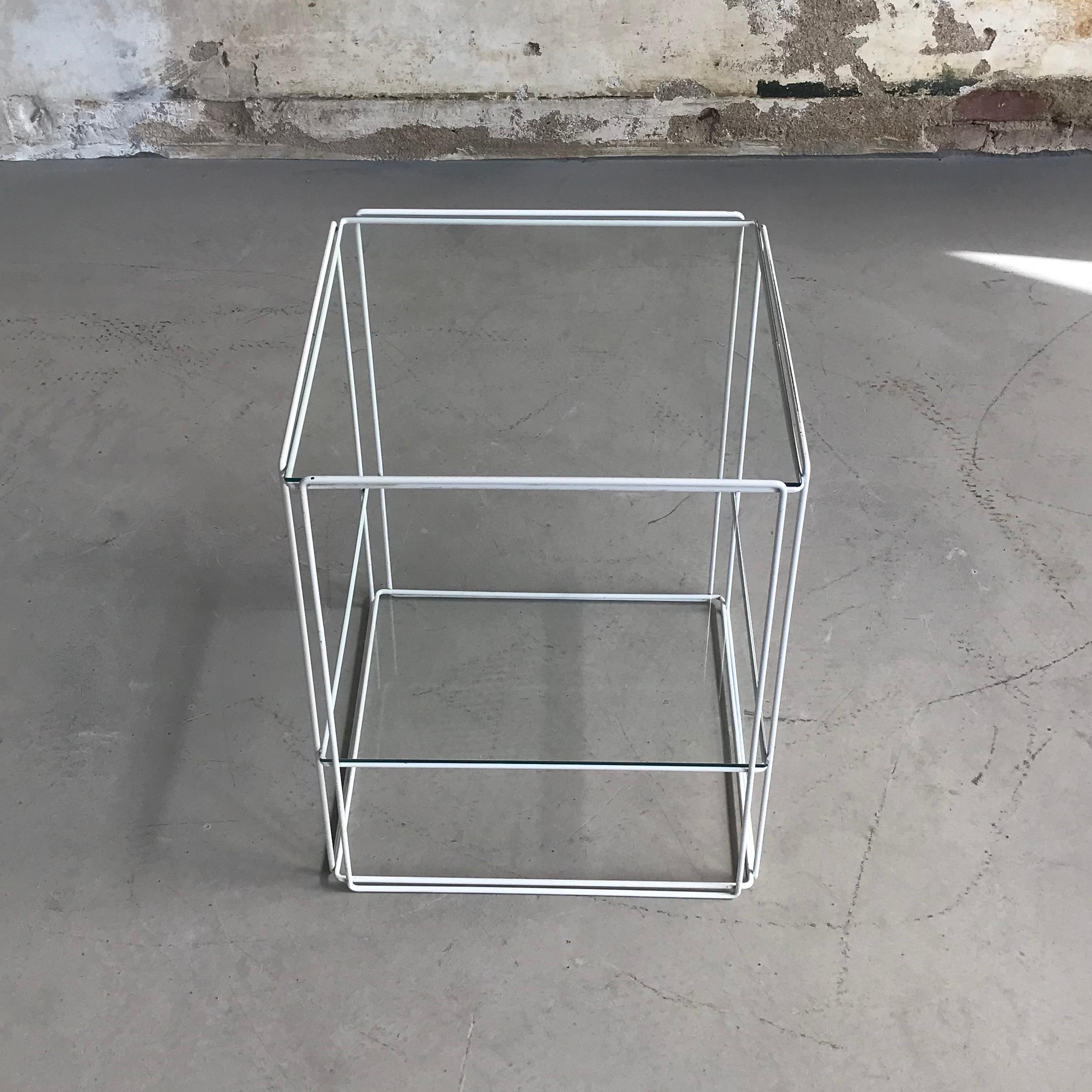 Beautiful Minimalist design by Max Sauze for Max Sauze Studio or Atrow, circa 1970. This table features a white colored metal base and two glass 'shelves'. The glass and metal wire structure gives this table a very transparent, minimal look, but