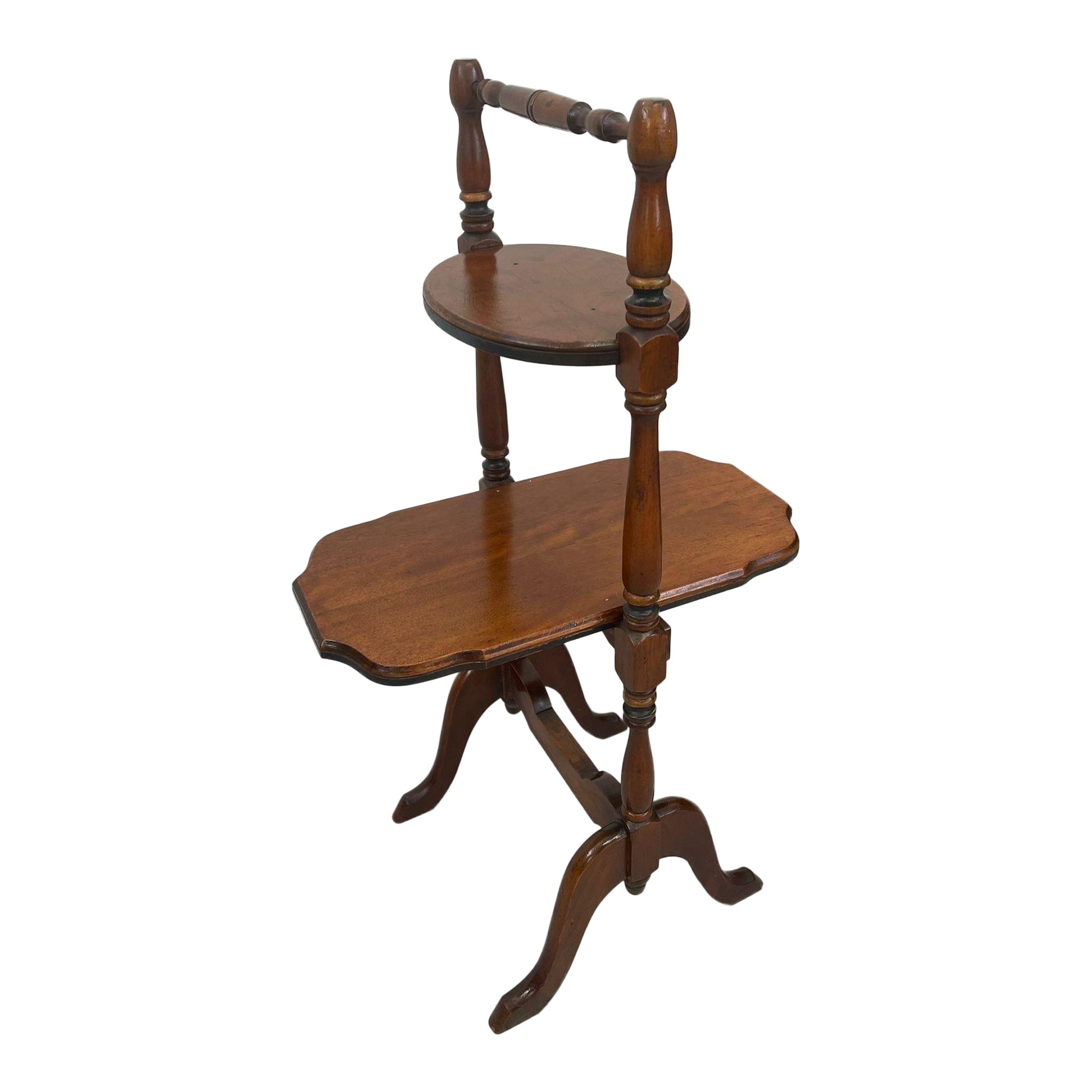 Mesa auxiliar vintage de dos niveles con patas talladas.
