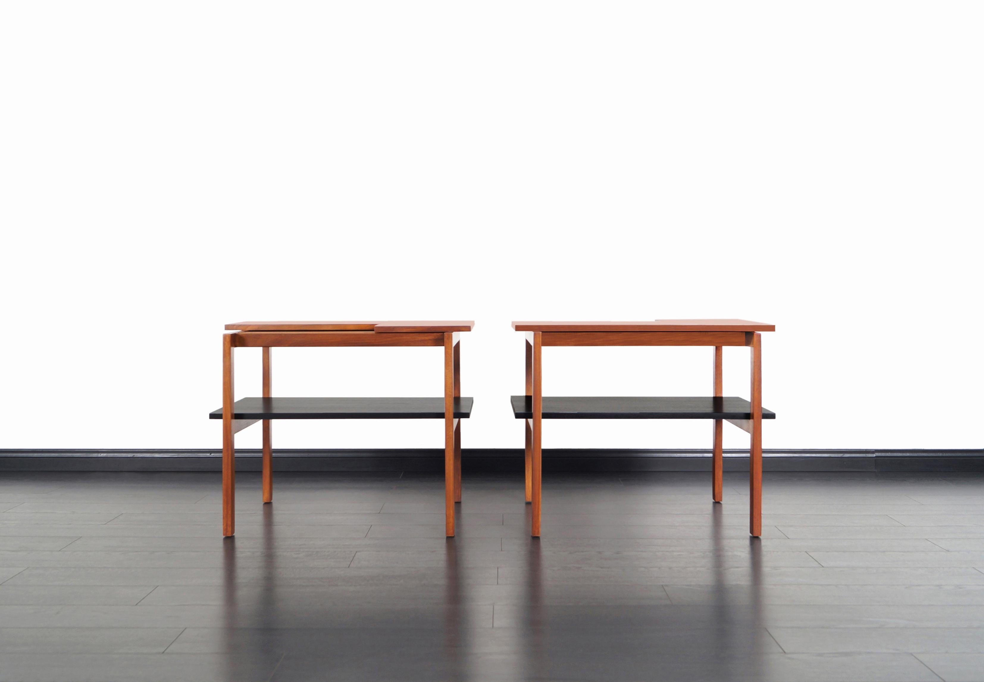 Rare pair of vintage two-tiered side tables designed by the legendary Swedish architect Greta M. Grossman for Glenn of California in the 1950s. Its walnut frame and slats design create a compelling mix of lines, turning them into gems to any