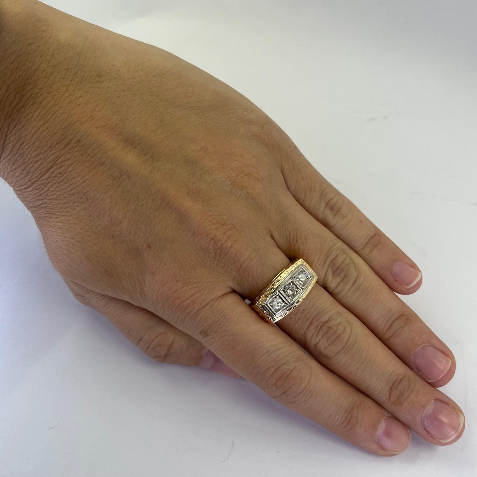 18 karat yellow gold vintage 3 stone ring with engraved flower detail featuring 3 transitional cut diamonds of I1 clarity and H color totaling approximately 0.50 carats. Finger size 7.75 with white gold accents. Includes one sizing service upon