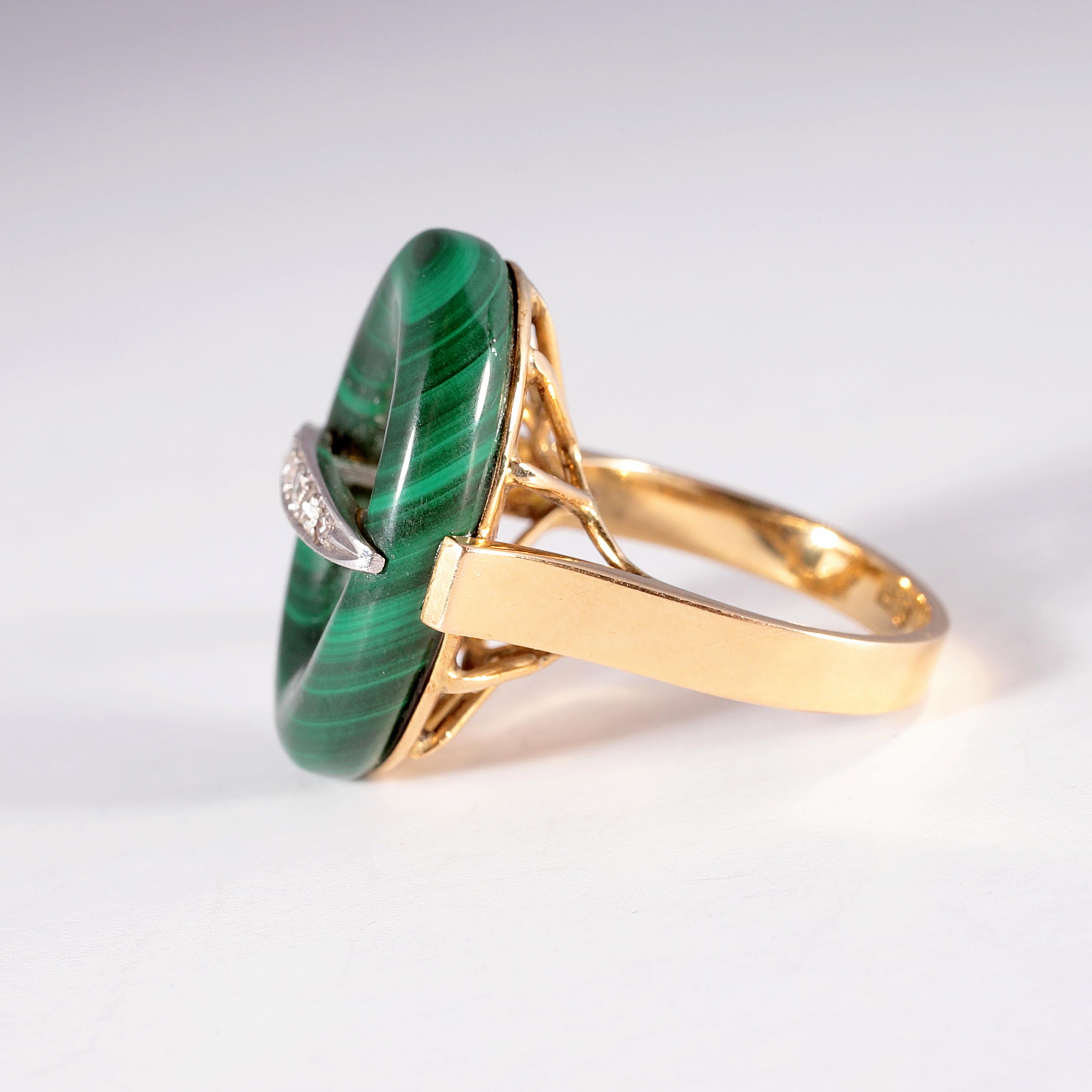 This beautiful yellow and white gold ring, with pierced undergallery, supports a stunning oval-shaped malachite - with an accent diamond bar across the center.  Size 6