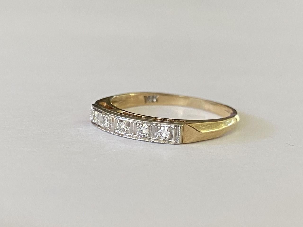 This vintage two-toned band features a row of five single cut diamonds totaling approximately 0.10 carats set in 14kt yellow and white gold. 