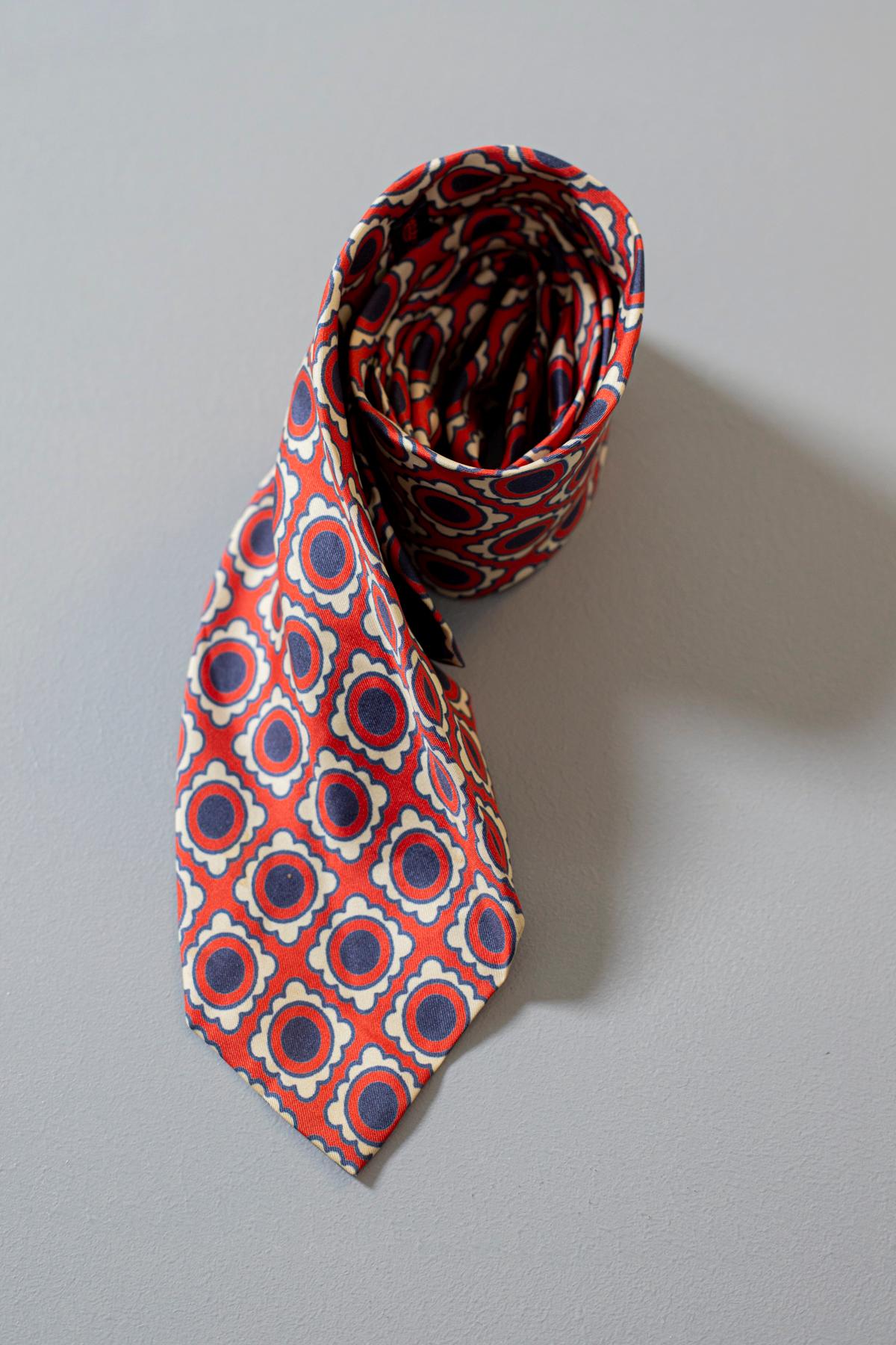 Unique, inimitable, elegant, this tie designed by U Pavesi Milano is made of 100% silk. Decorated with small blue circles on a white frame, the main color of the tie is red, ideal to combine with a dark suit. It is the perfect accessory to make your