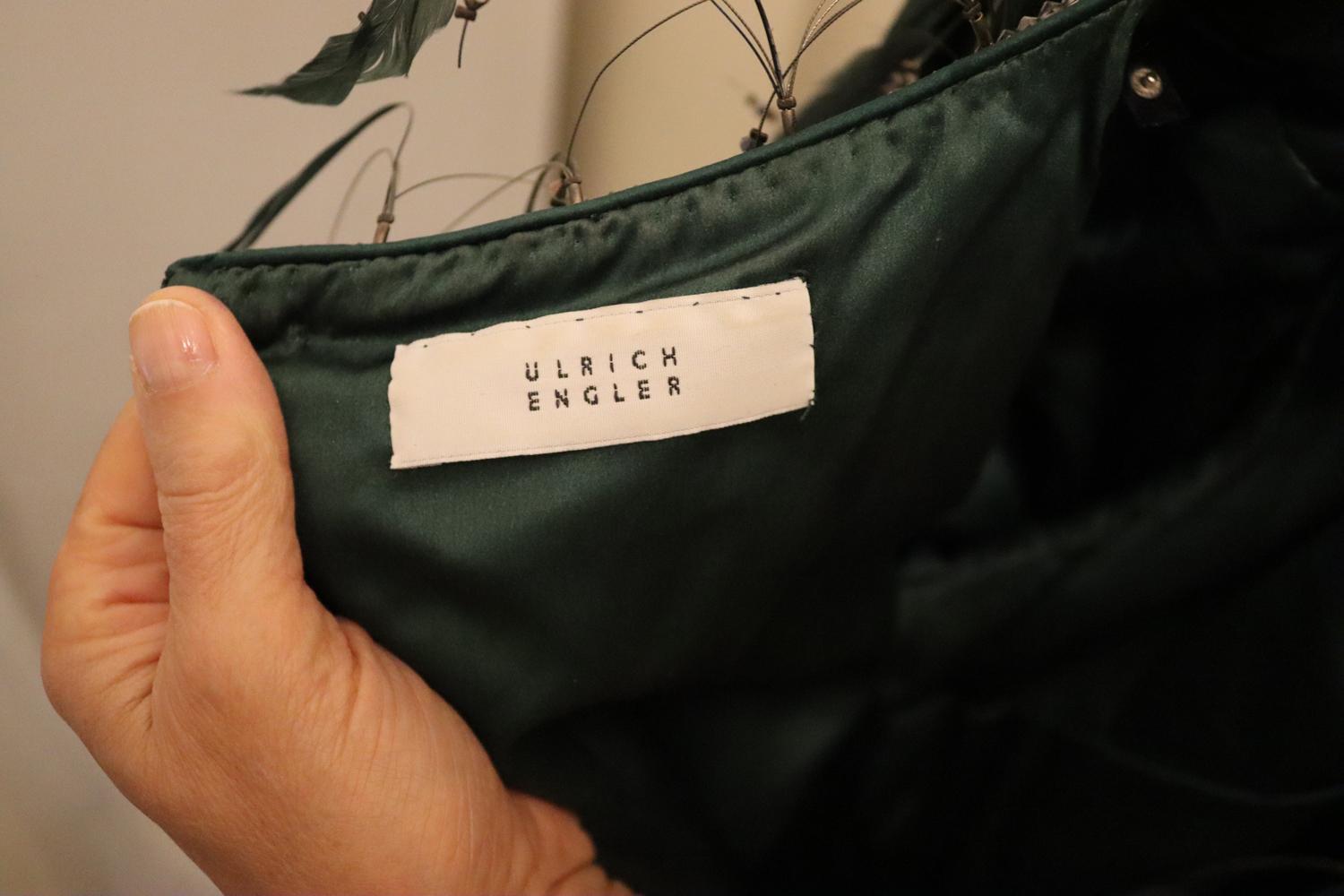 A stunning silk velvet couture evening gown by Ulrich Engler. In a wonderful Christmas tree green , the dress has feather detail on the neckline and cuffs - they can be easily detached. It has a contrasting waistband, round neckline and back zip and