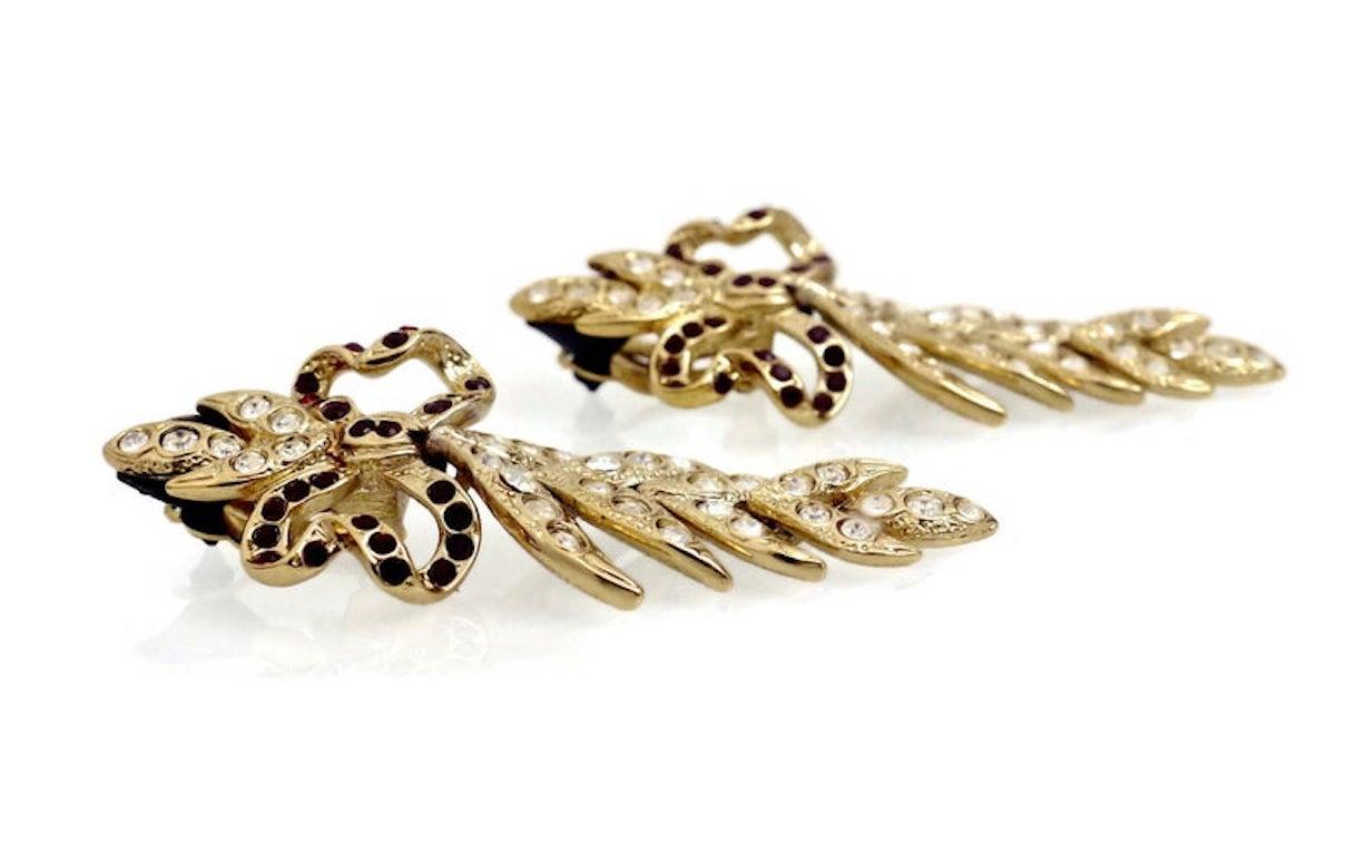 Vintage Ultra Long Yves Saint Laurent Bow Leaf Rhinestone Earrings

Measurements:
Height: 3 1/8 inches
Width: 1 3/8 inches

Features:
- 100% Authentic YVES SAINT LAURENT.
- Bow embellished with ruby rhinestones.
- Articulated leaf embellished with