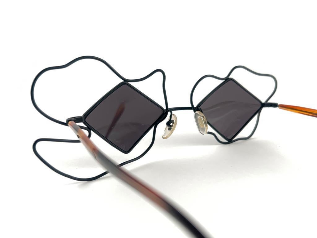 Seldom Vintage Rare Claude Montana whimsical shock wave frame.

Solid grey lenses.

Please consider that this item is nearly 40 years old so it could show minor sign of wear due to storage.

Made in France.

MEASUREMENTS :

FRONT :  15 CMS
LENS