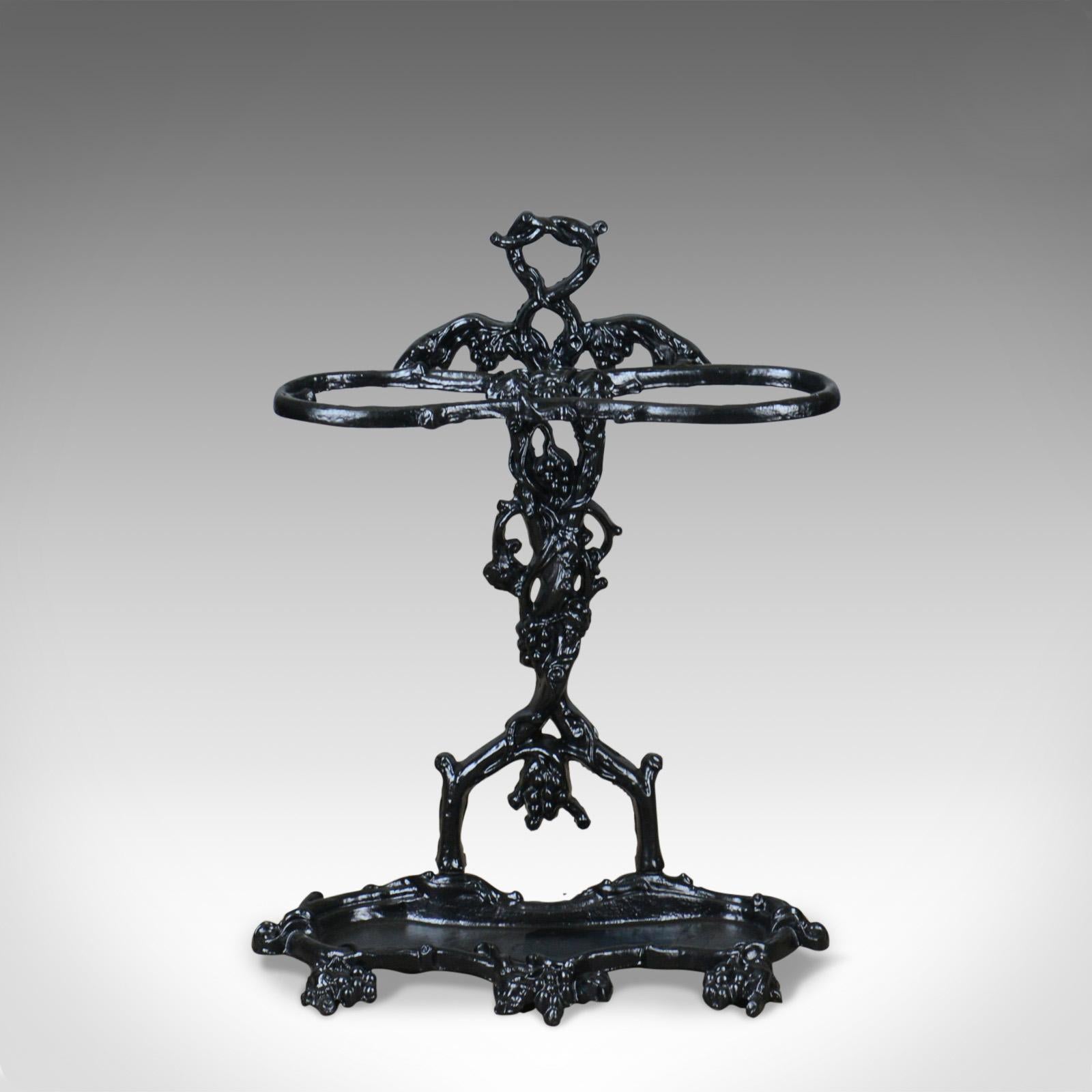 This is a vintage umbrella or stick stand, a painted foundry cast iron, hall stand in the Victorian, Coalbrookdale manner dating to the 20th century.

Attractively cast in heavy iron depicting fruiting vines
Solid and robust suitable for indoor