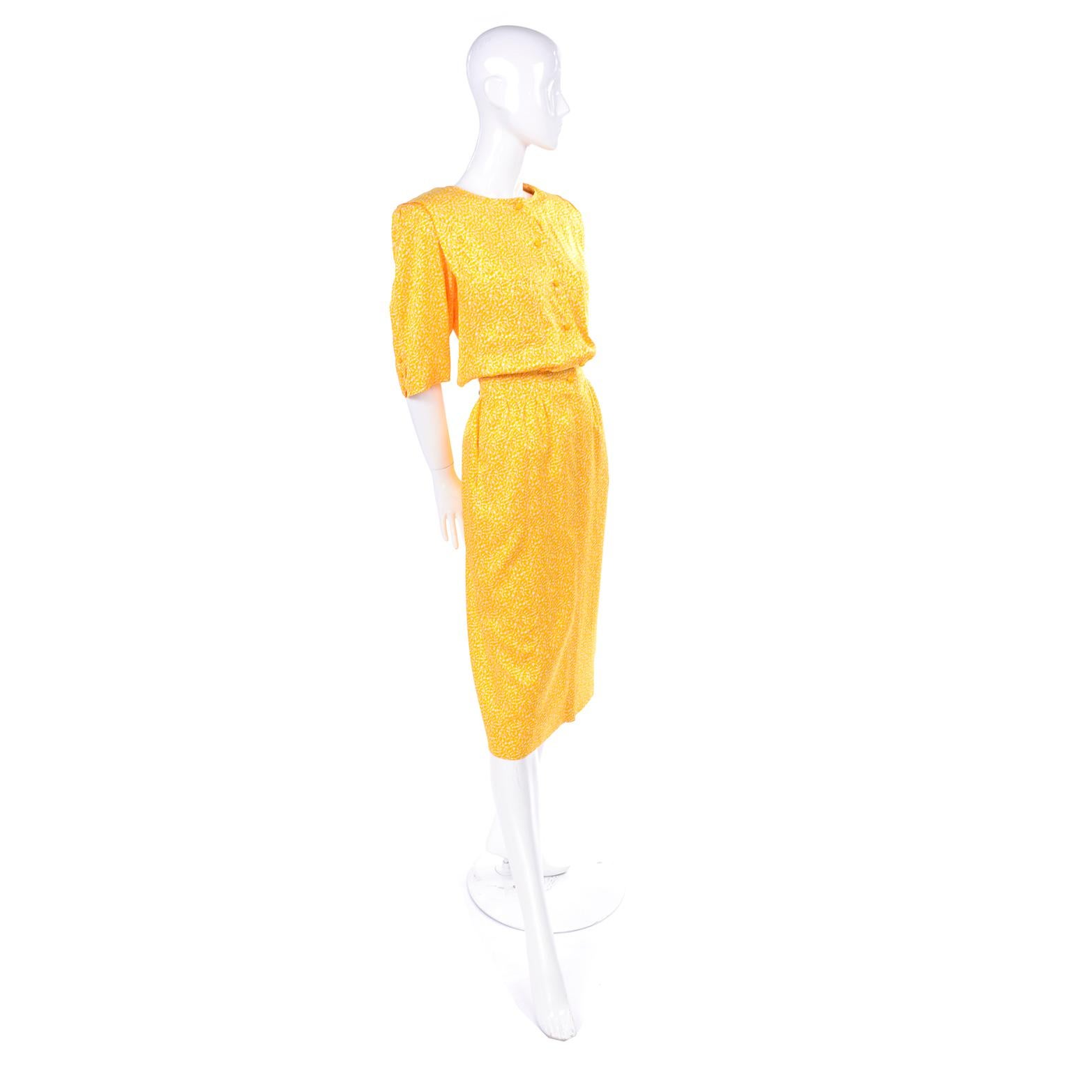 This is a very pretty yellow and white rayon dress from Ungaro.  The dress has the Emanuel Ungaro Parallele Paris label, two breast pockets and two side slit hip pockets. It has shoulder pads with pleats over the shoulders. The sleeves hit just