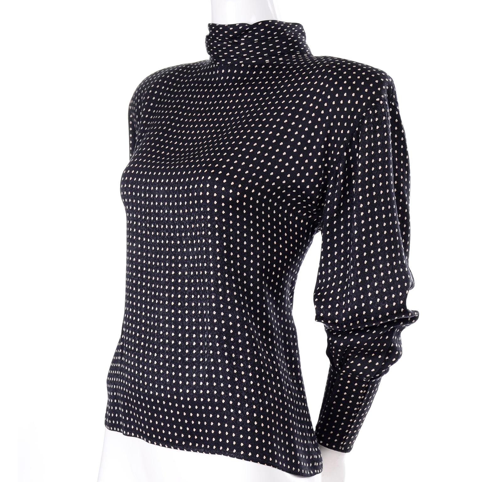 This is a lovely vintage early 1980's Ungaro Parallele Paris blouse in black silk with white polka dots and a gathered high neck. This top buttons up the back with black faceted buttons.  It has dramatic shoulder pads for structure and unique leg of