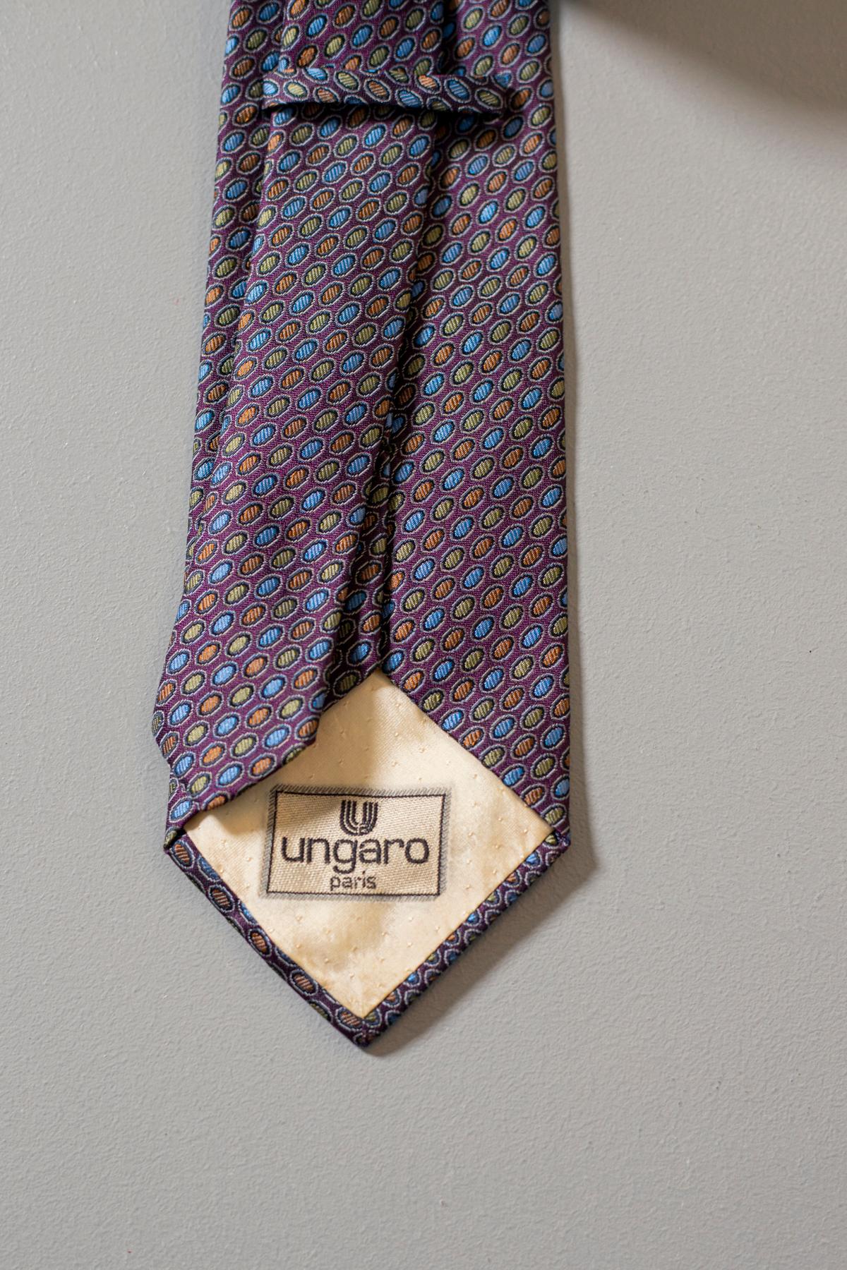 Elegant tie in silk designed by the stylist Ungaro Paris.
This vintage tie is colorful, yet classic. Decorated with small orange, green and blue circles, it gives a touch of style to your outfit. It is a perfect tie for an evening of work, or a