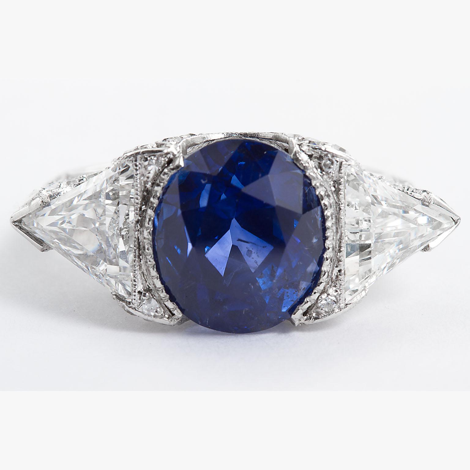 A remarkably dignified oval shape Ceylon sapphire and diamond ring.  Center sapphire is 6.26 carats and Unheated. It's set between two triangle shape diamonds of high color and clarity, 2.08 ctw, in a handsome diamond mellee (1.00 ctw) and