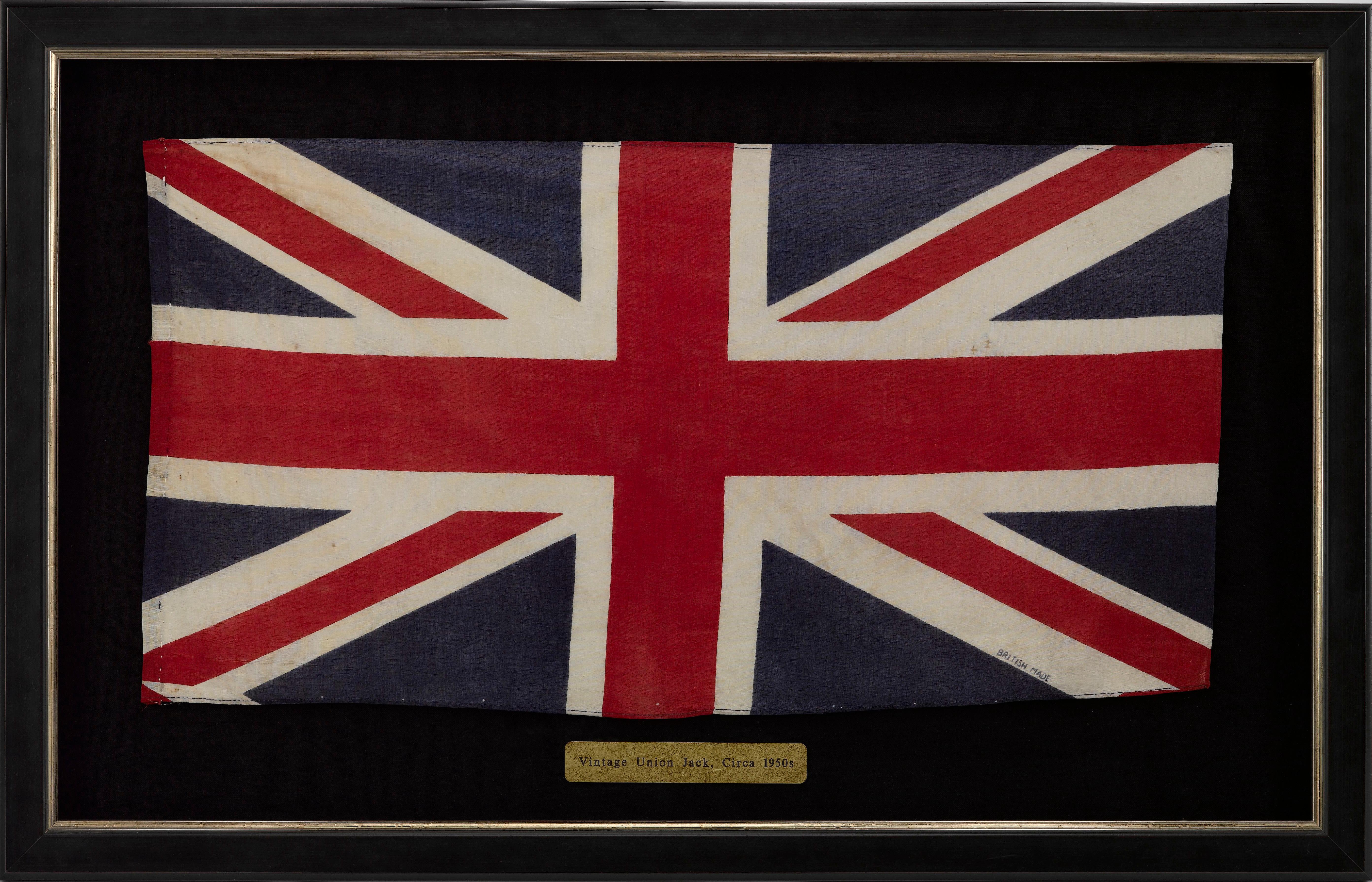 This is a beautiful Union Jack parade flag, dating from the early 1950s, during the early years of Queen Elizabeth II's reign. The flag is printed on cotton, with machine-sewn hemmed top and bottom. The flag has a hand-sewn envelope hoist and is