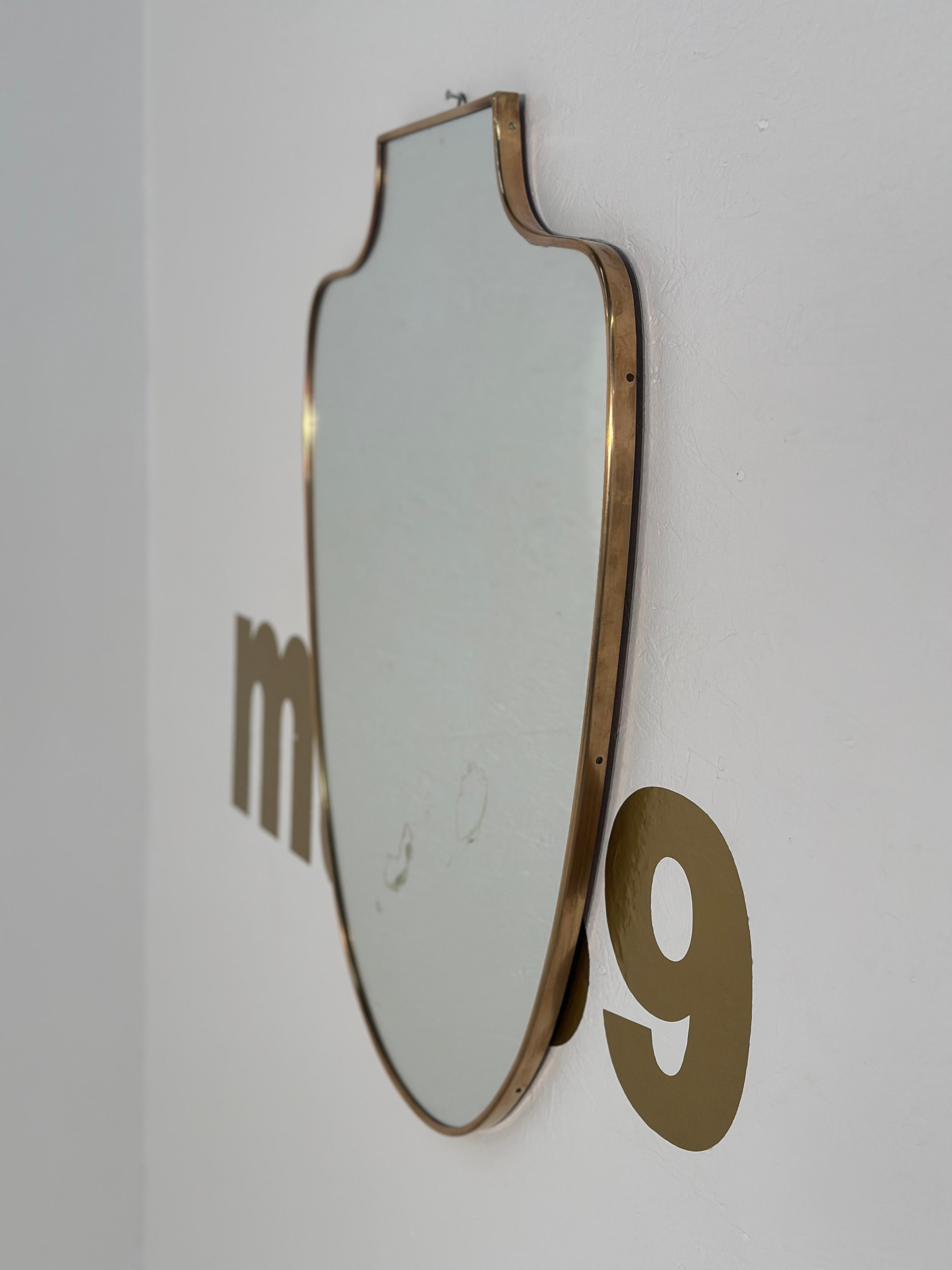 The Vintage Unique Brass Wall Mirror from the 1970s is a striking decor piece featuring a brass frame with intricate detailing, adding a touch of retro elegance to any space.

