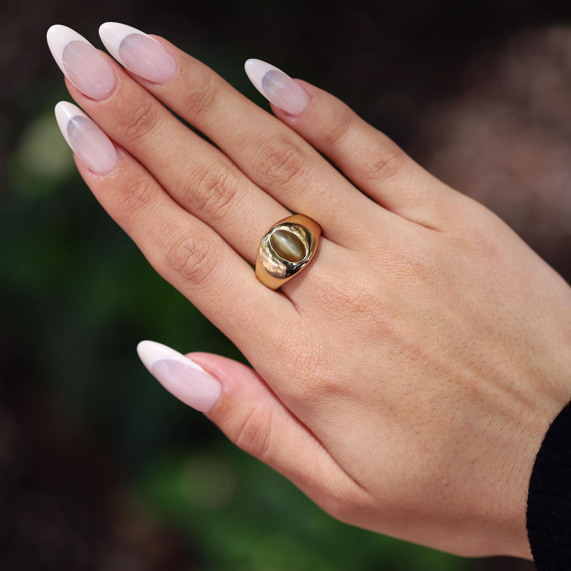 A classic mid century estate cocktail ring, with a compellingly hypnotic center gemstone. The all natural cat's eye chrysoberyl displays a striking natural phenomenon that is extremely rare, and weighs an impressive 3.24 carats. The gem's wonderful