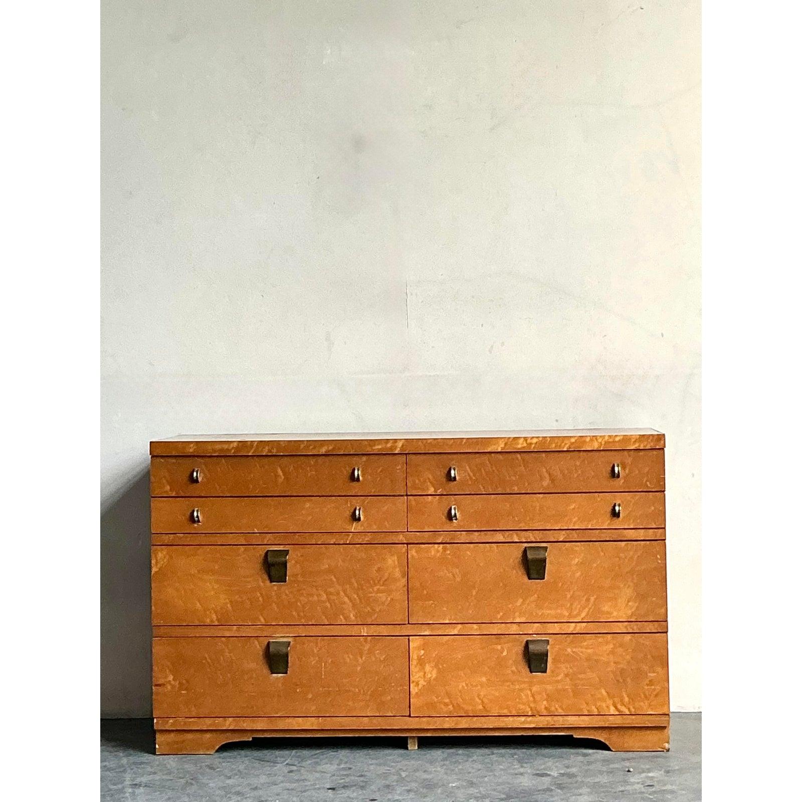 Diese hübsche Kommode mit neun Schubladen von United Furniture steht für die zeitlose Anziehungskraft der amerikanischen Handwerkskunst der Jahrhundertmitte. Dieses Stück zeichnet sich durch ein reich gemasertes Wurzelholzfurnier aus, das eine