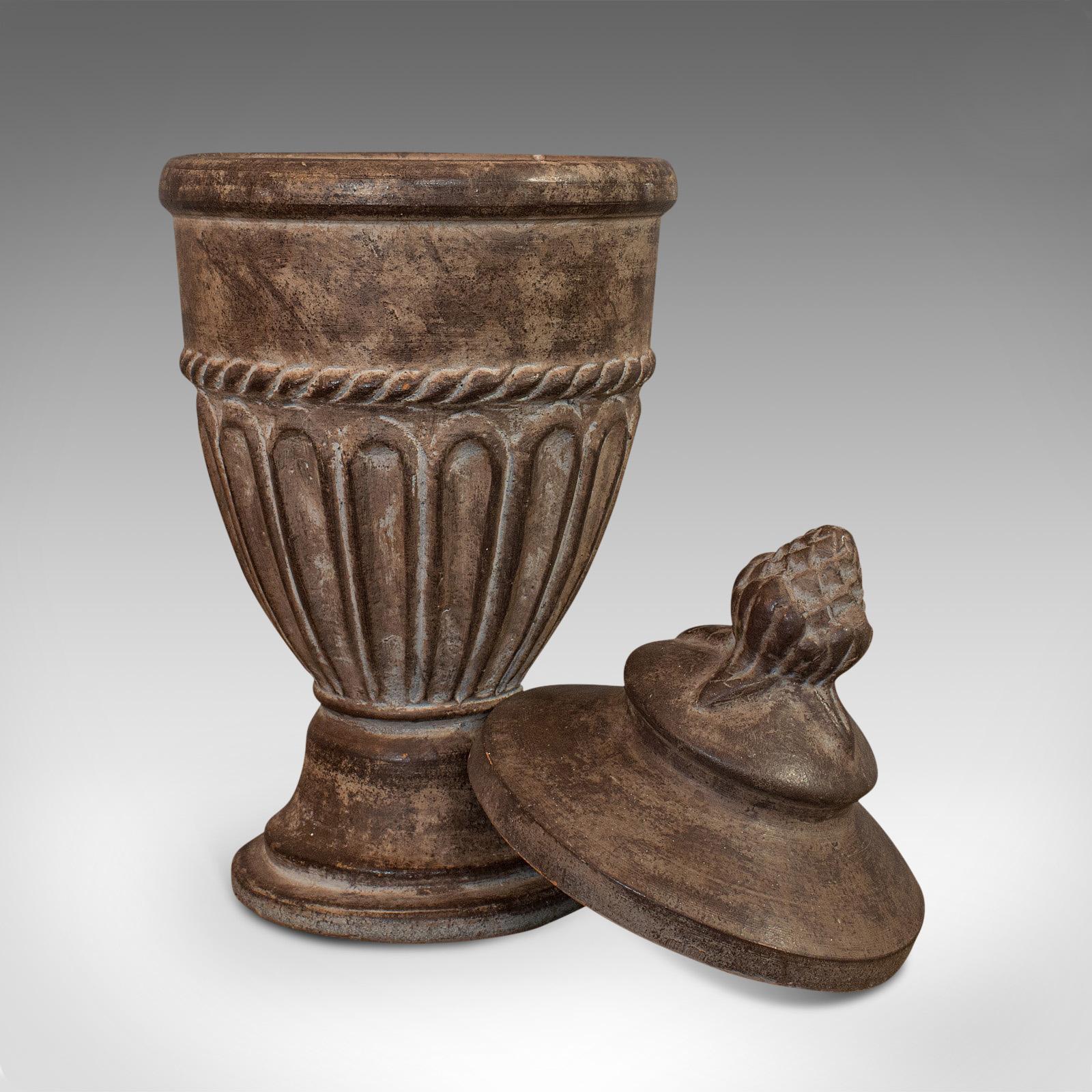 This is a vintage urn. An English, terracotta decorative garden or fireside ornament, dating to the late 20th century, circa 1980.

Appealing decorative piece with earthen hues
Displays a desirable aged patina
Thick terracotta offers a pleasing