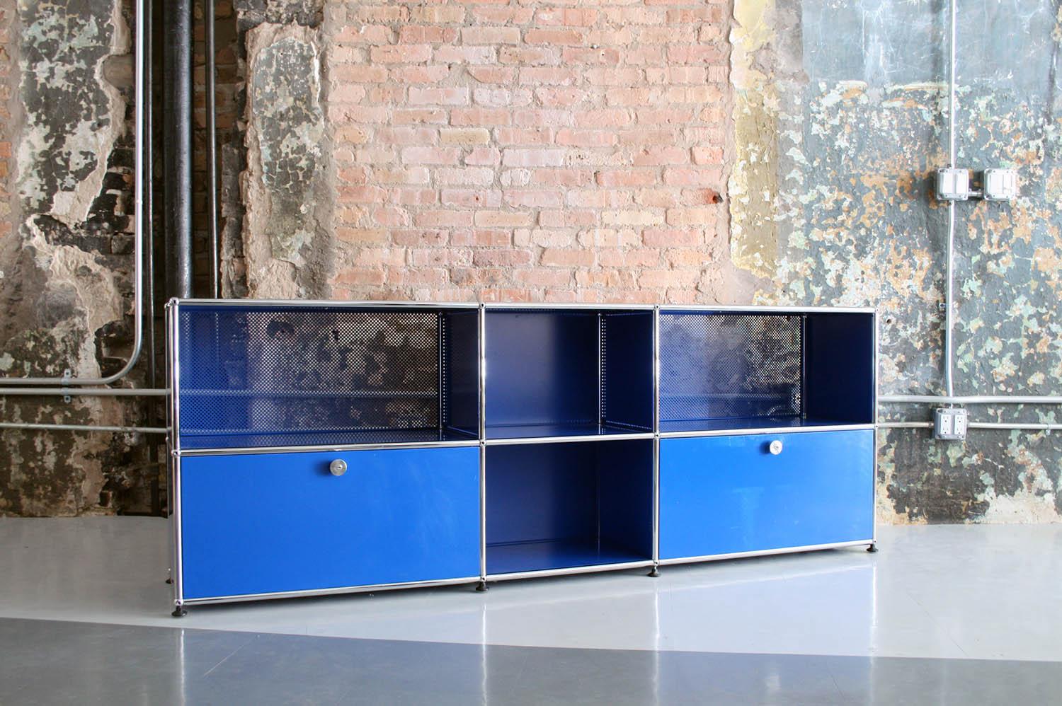 A beautiful blue metal cabinet with 2 drop down doors made by USM Haller designed by Fritz Haller. Great condition. Minor wear to the top surface otherwise in great condition.

Top shelves are: 14