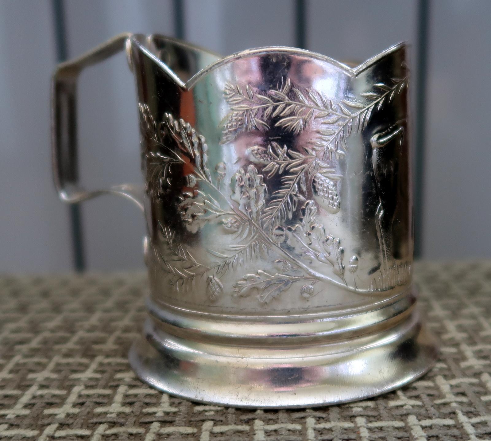 Transport yourself back to the 1970s with this vintage USSR cup holder. Meticulously crafted from sturdy metal, it carries a surprisingly lightweight feel. The captivating design showcases an artful engraving of a majestic bison amidst towering