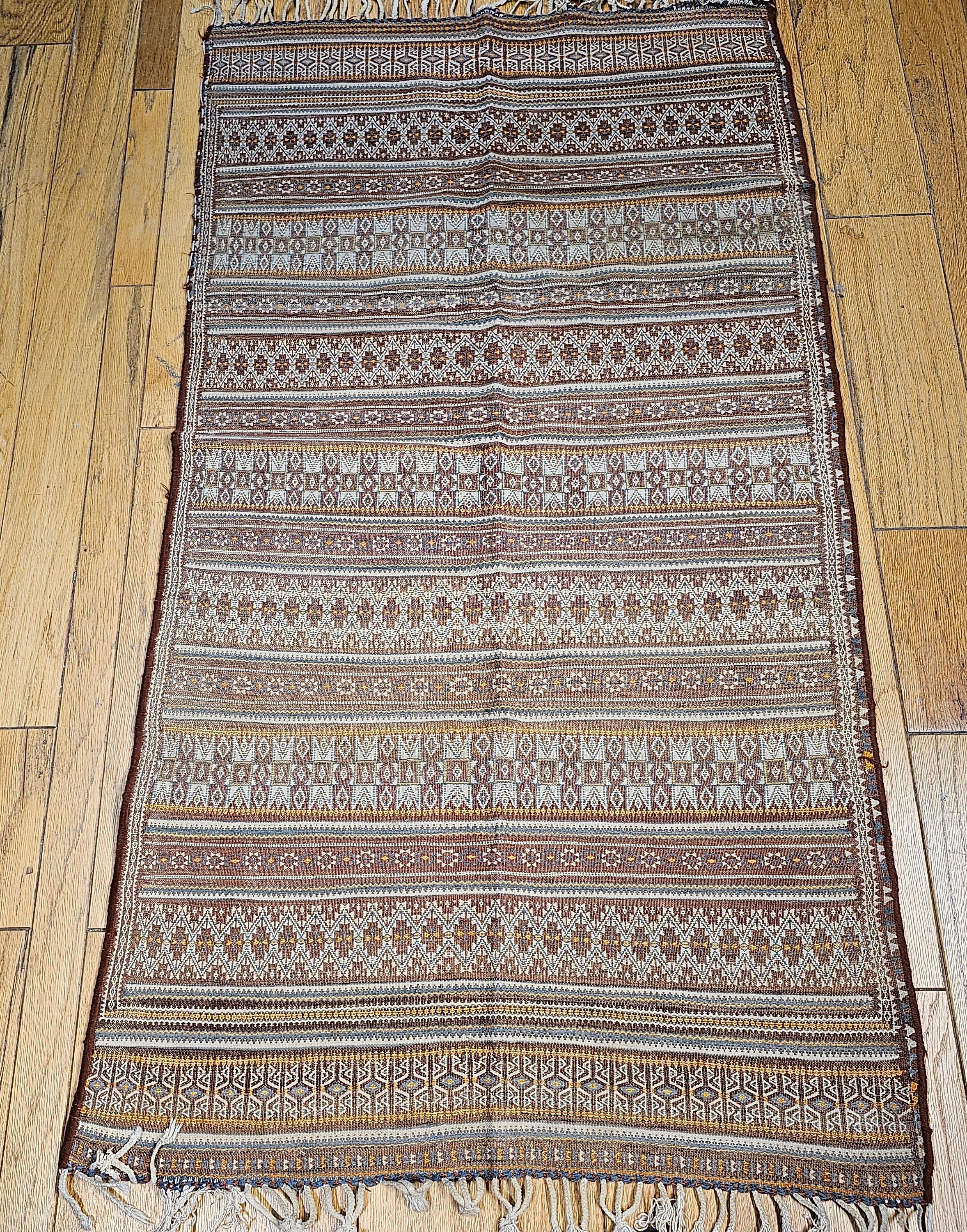 A beautiful Uzbek soumak kilim from Central Asia from the early 1900s.  The Uzbek Kilim is woven in the soumak method with rows of different designs in ivory, brown, green, and burgundy colors.  The Kilim is a great representation of the artistry