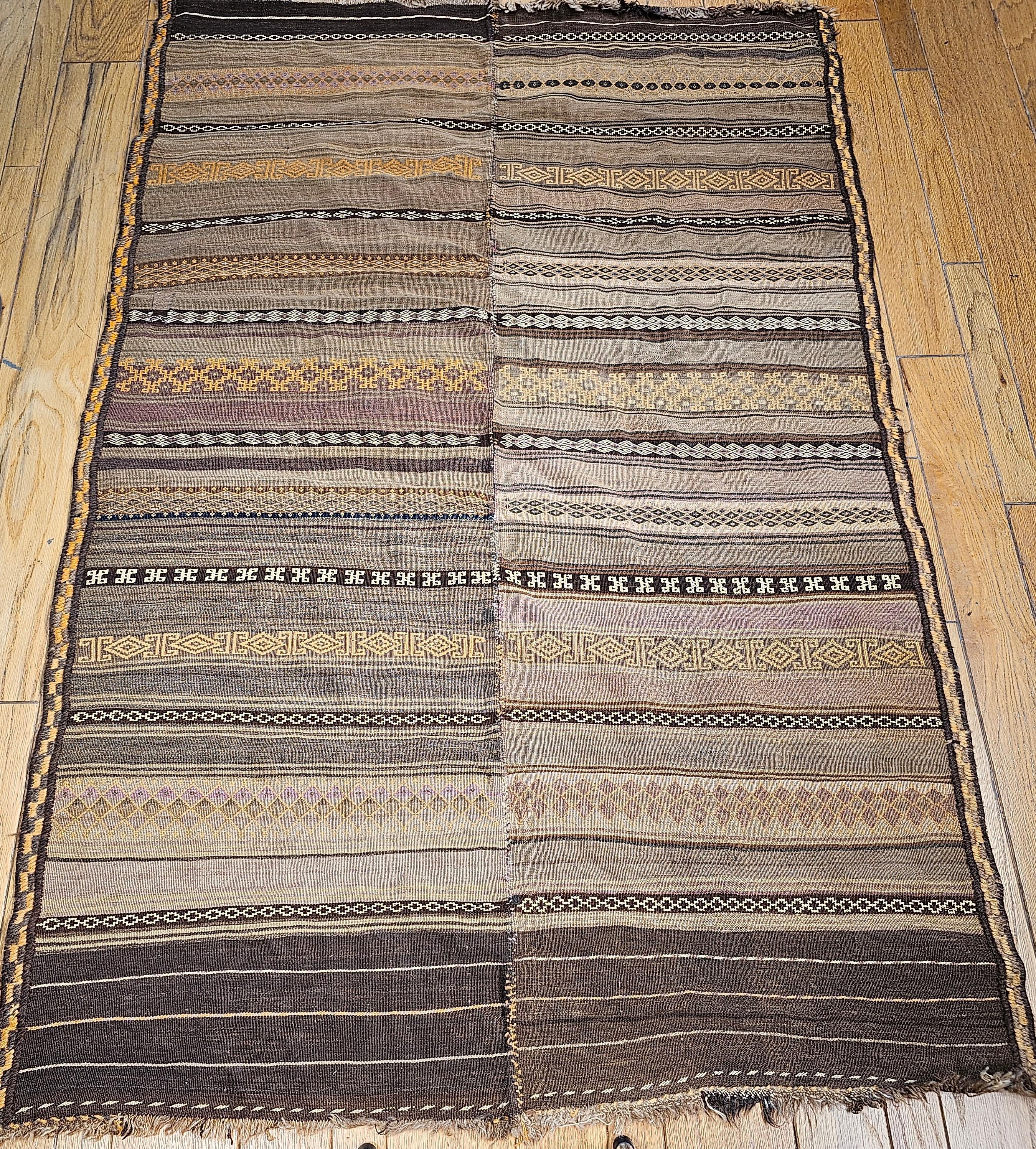 Vintage Uzbek flat woven soumak kilim from Central Asia from the early 1900s.  The Uzbek Kilim is woven in the soumak method with rows of different designs in ivory, brown, green, burgundy, and lavender colors.  The Kilim is a great representation
