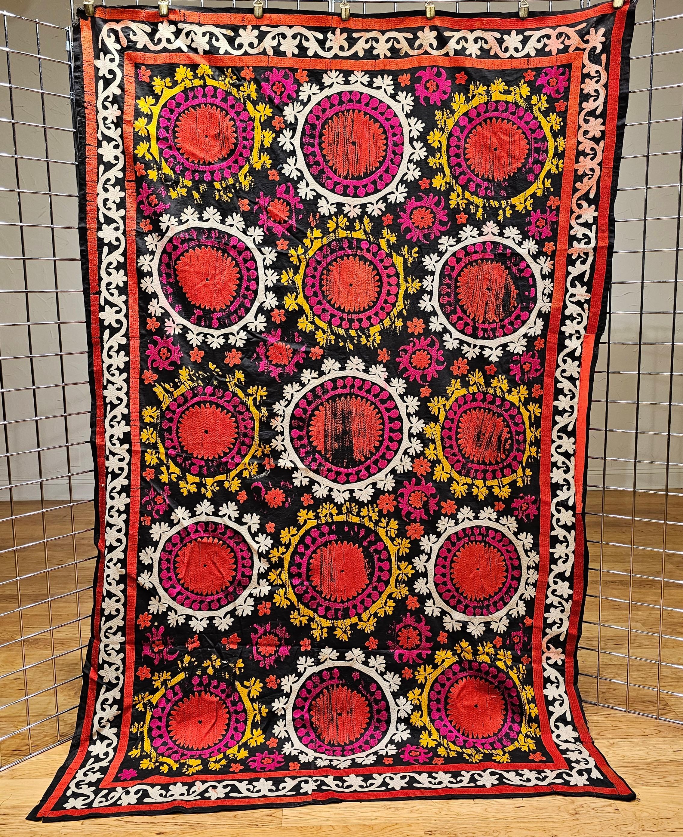 Handgefertigte Vintage-Susani-Seidenstickerei aus Usbekistan in Zentralasien mit schwarzem Baumwollgrund und Seidenmustern in Schwarz, Elfenbein, Gelb und Rot.  Das Design jedes Paneels besteht aus fein seidengestickten Blumenmustern in leuchtenden