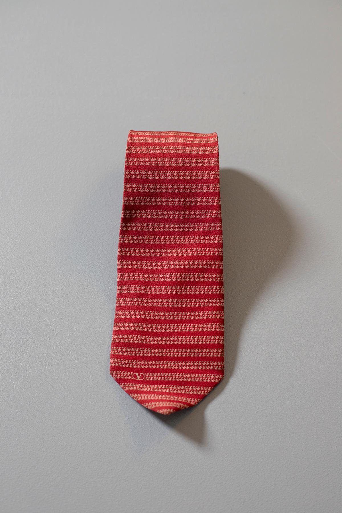 Elegant mid-century tie designed by the Italian stylist Valentino. It is made of 100% silk .
A tie of timeless elegance. The bright red color with white color motifs is perfect for a job interview or even a dinner with friends/ colleagues, an