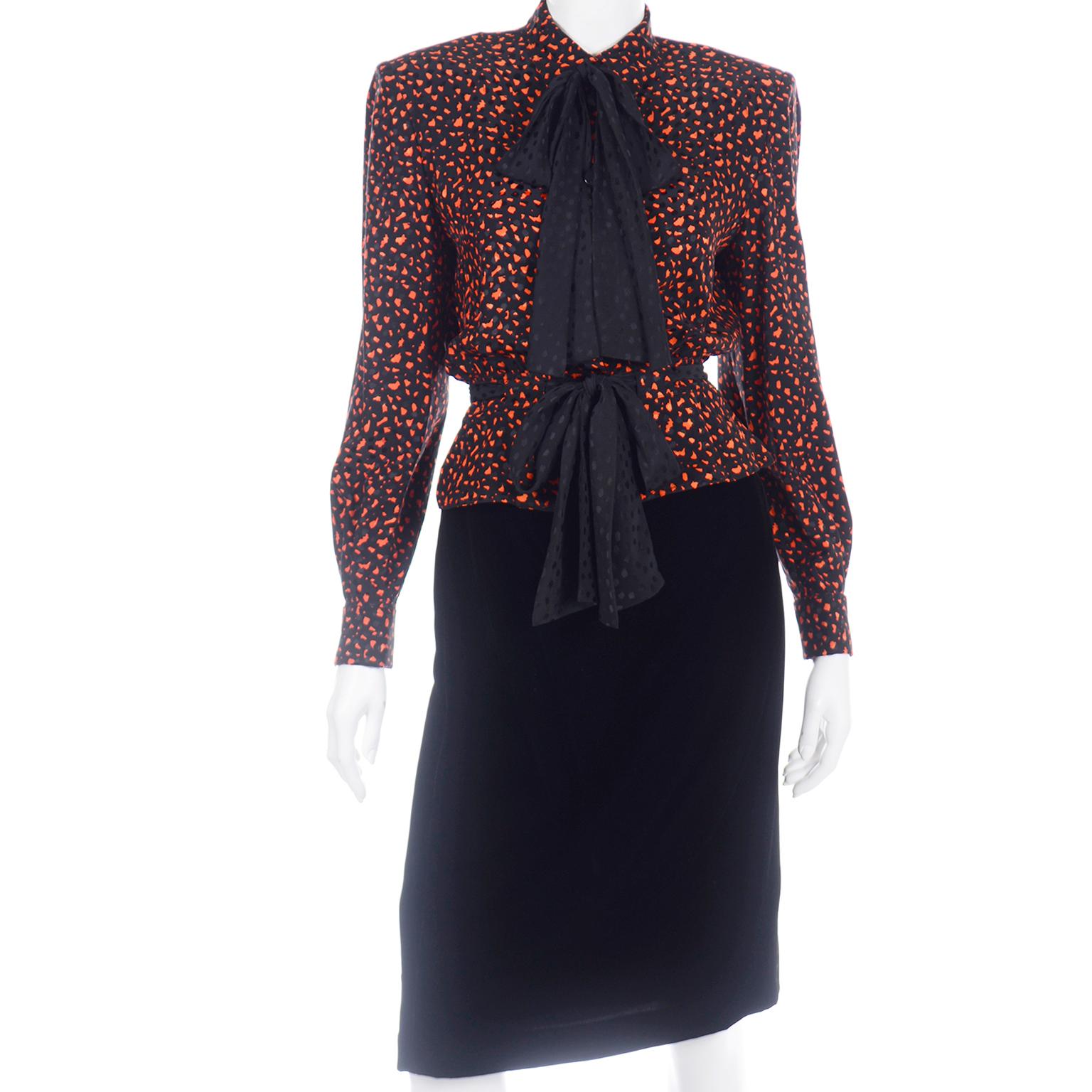 Si tratta di un favoloso abito vintage di Valentino Miss V con uno splendido blazer in lana arancione con finiture in velluto nero, una gonna sottile in velluto nero e una bellissima camicetta in seta stampata arancione e nera con fusciacche nere. 