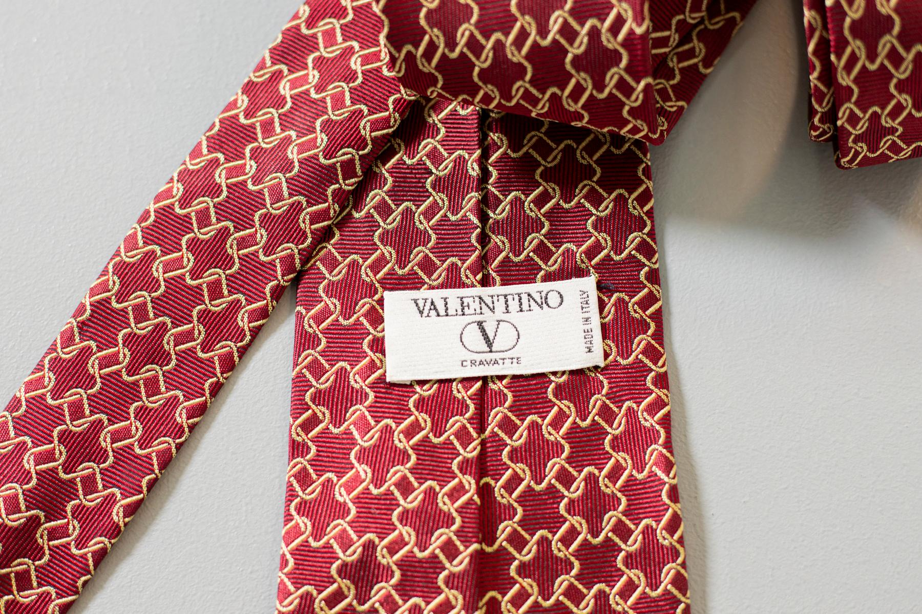 Unique, elegant, yet just enough showy. This all-silk tie designed by Valentino and made in Italy is perfect for every occasion. Decorated with small golden chains on a dark red background, this tie will make you feel like a royal. 