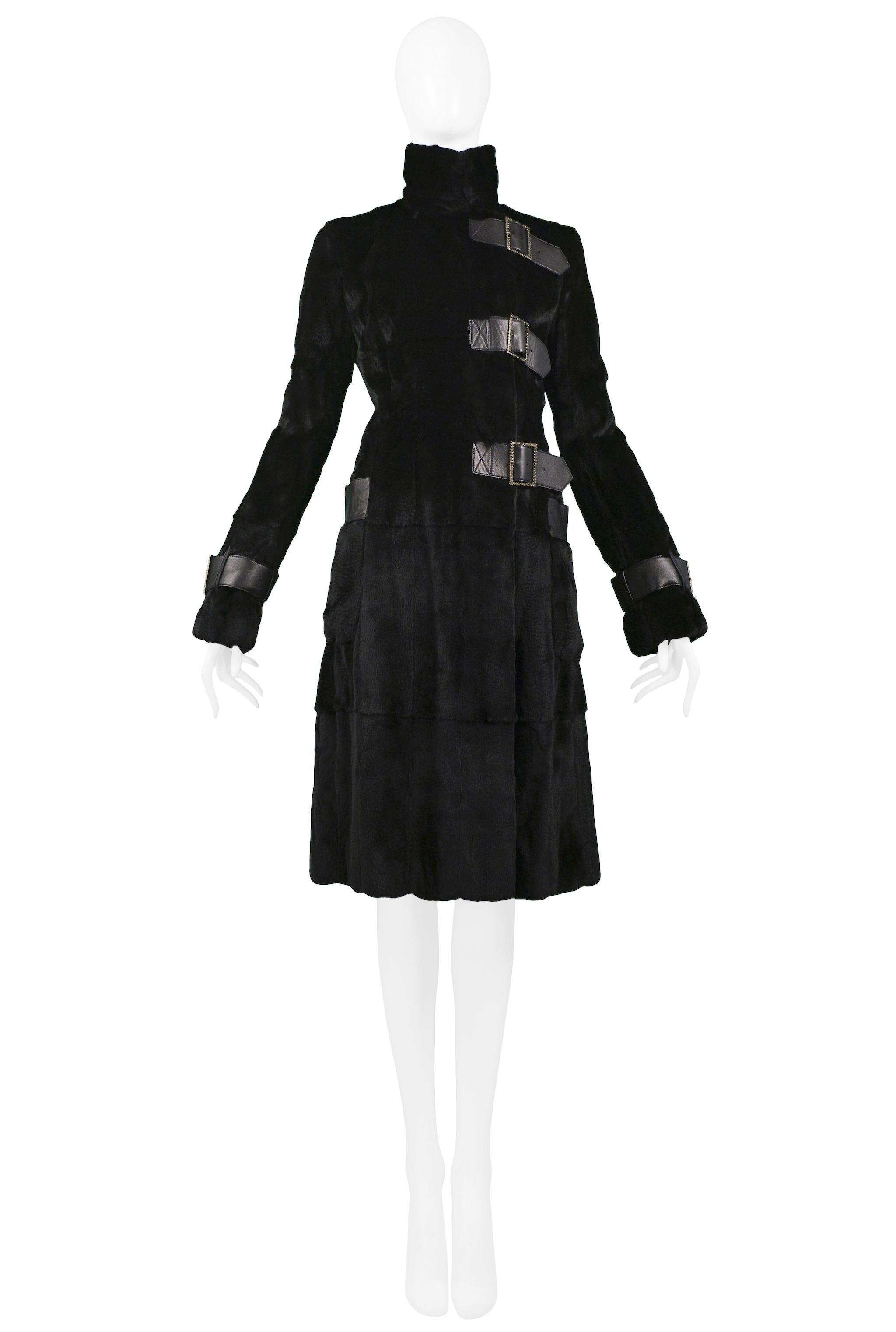 Vintage Valentino black weasel fur knee-length coat featuring a standing collar, offset black leather straps with rhinestone buckles at center front closure and at cuffs, and black leather-trimmed pockets at hips.

Excellent Vintage