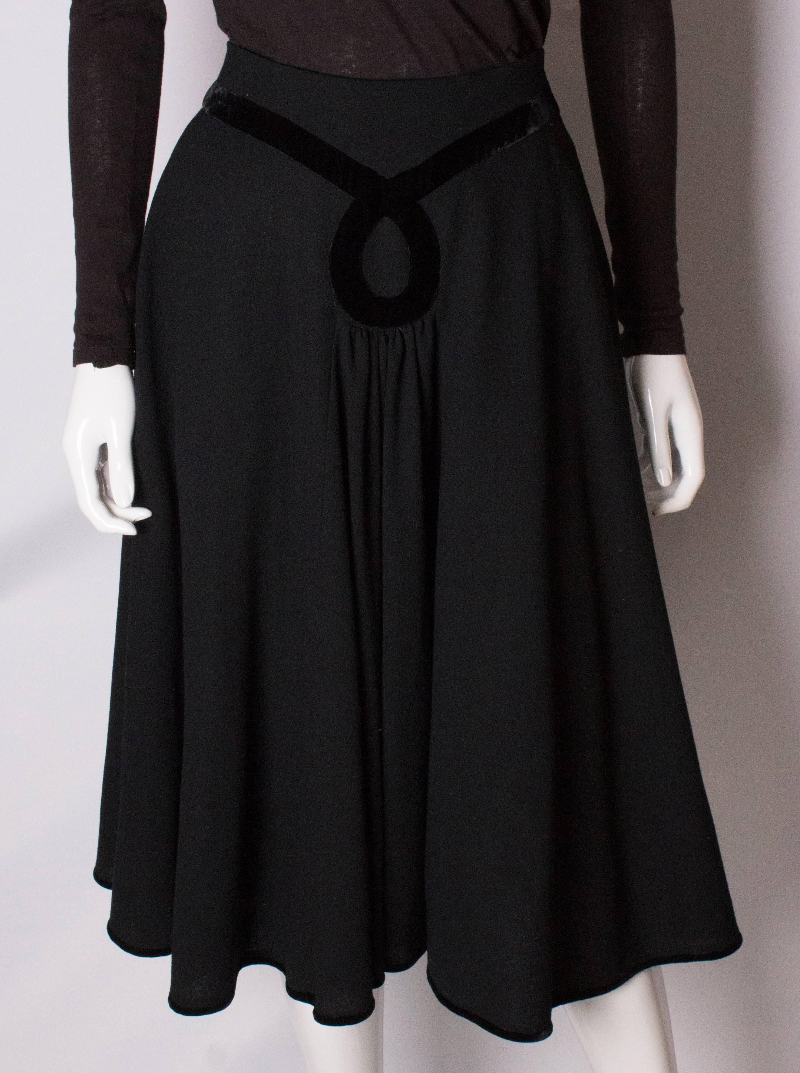 A chic vintage skirt by Valentino. The  skirt is in a black wool crepe, with black velvet detail on the front and hem. The skirt has a central back zip and pockets on both sides.