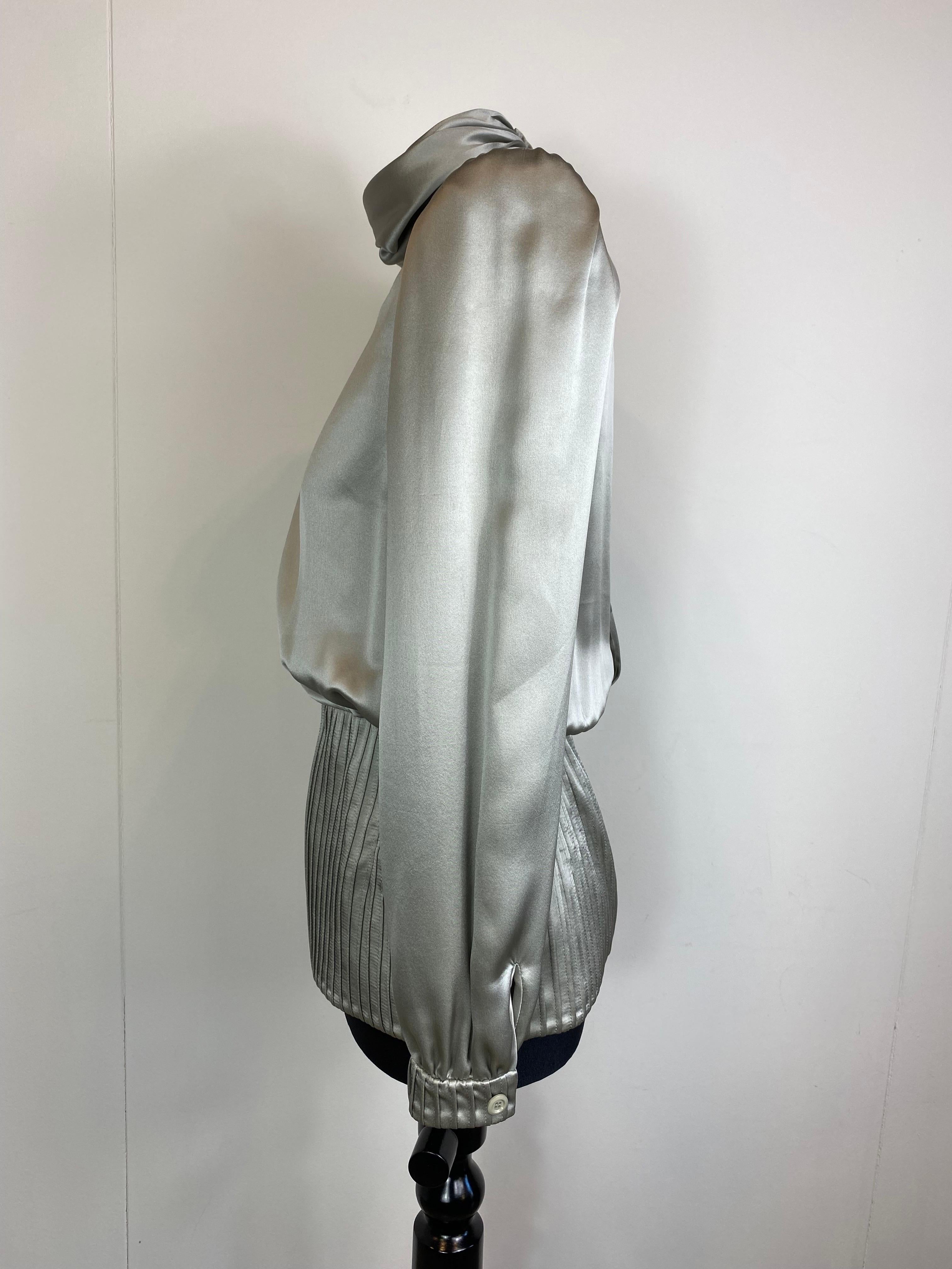 Vintage satin blouse by Valentino, pearl grey. 
The label of the composition is missing but it is made of silk.
With shoulder straps.
In perfect condition.
Size 6 
Shoulders 38 cm
Bust 48 cm
Waist 32 cm
Length 66 cm 
Sleeve length 61 cm 