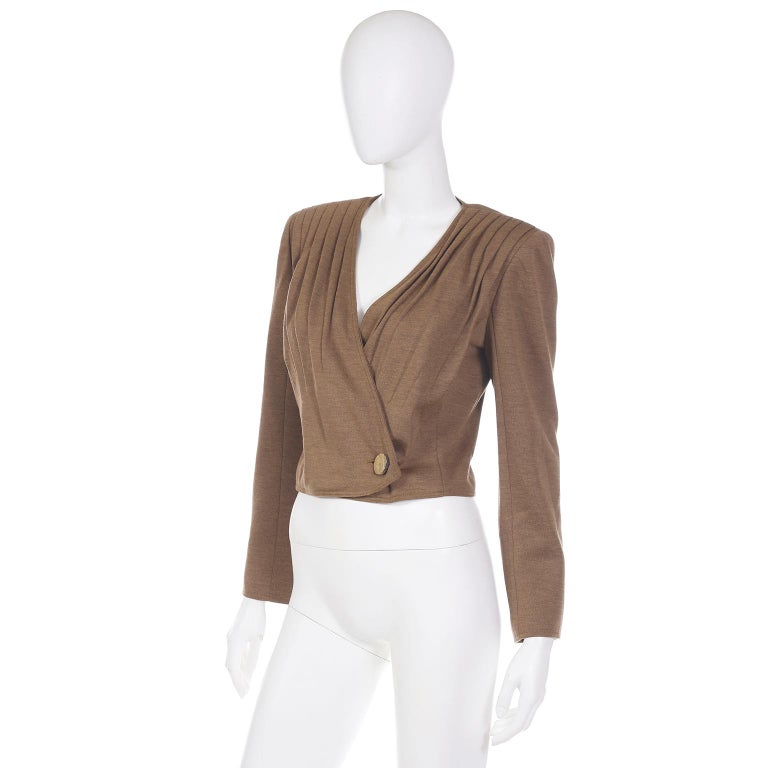 This vintage unworn deadstock Valentino boutique jacket is in a light brown wool blend and has so much style! This great fully lined, cropped jacket has beautiful front pleating starting at the shoulders. The jacket has a wrap closure at the waist
