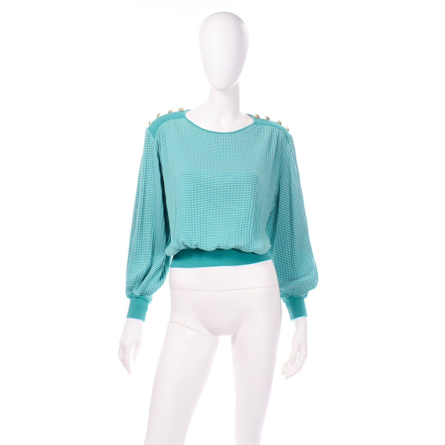 This is a vintage green long sleeve knit top from Valentino Studio in green and white stripes with gold tone engraved buttons along the shoulders. This oversized cotton blend knit sweater top has a micro pleated detail throughout with a ribbed