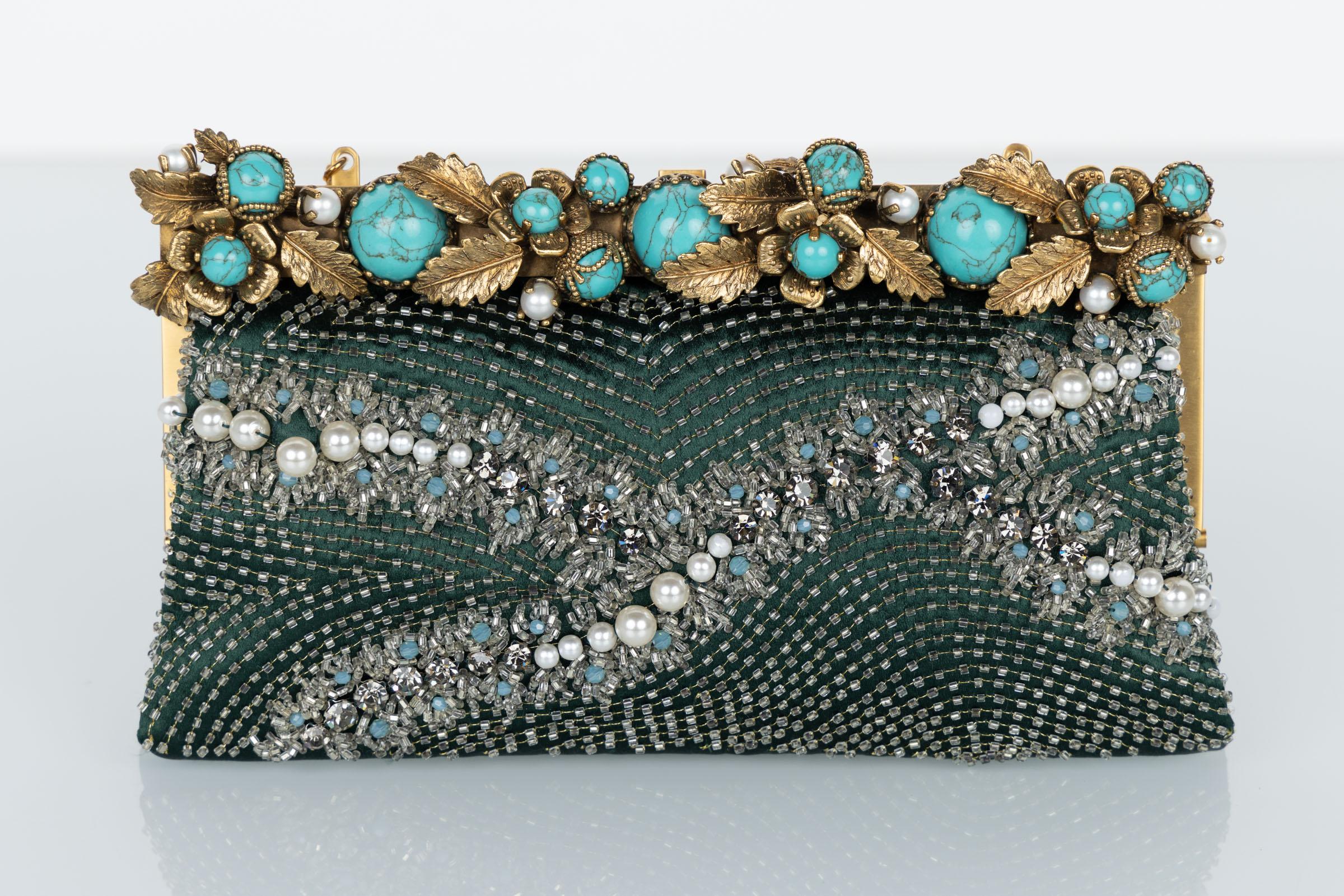 Vintage Valentino convertible bag/clutch. Done in an emerald satin with pearls and glass beads. The top of the bag is framed with gold sculpted leaves and striking turquoise cabochons. The bag is accented in gold-tone metal with a gold chain link