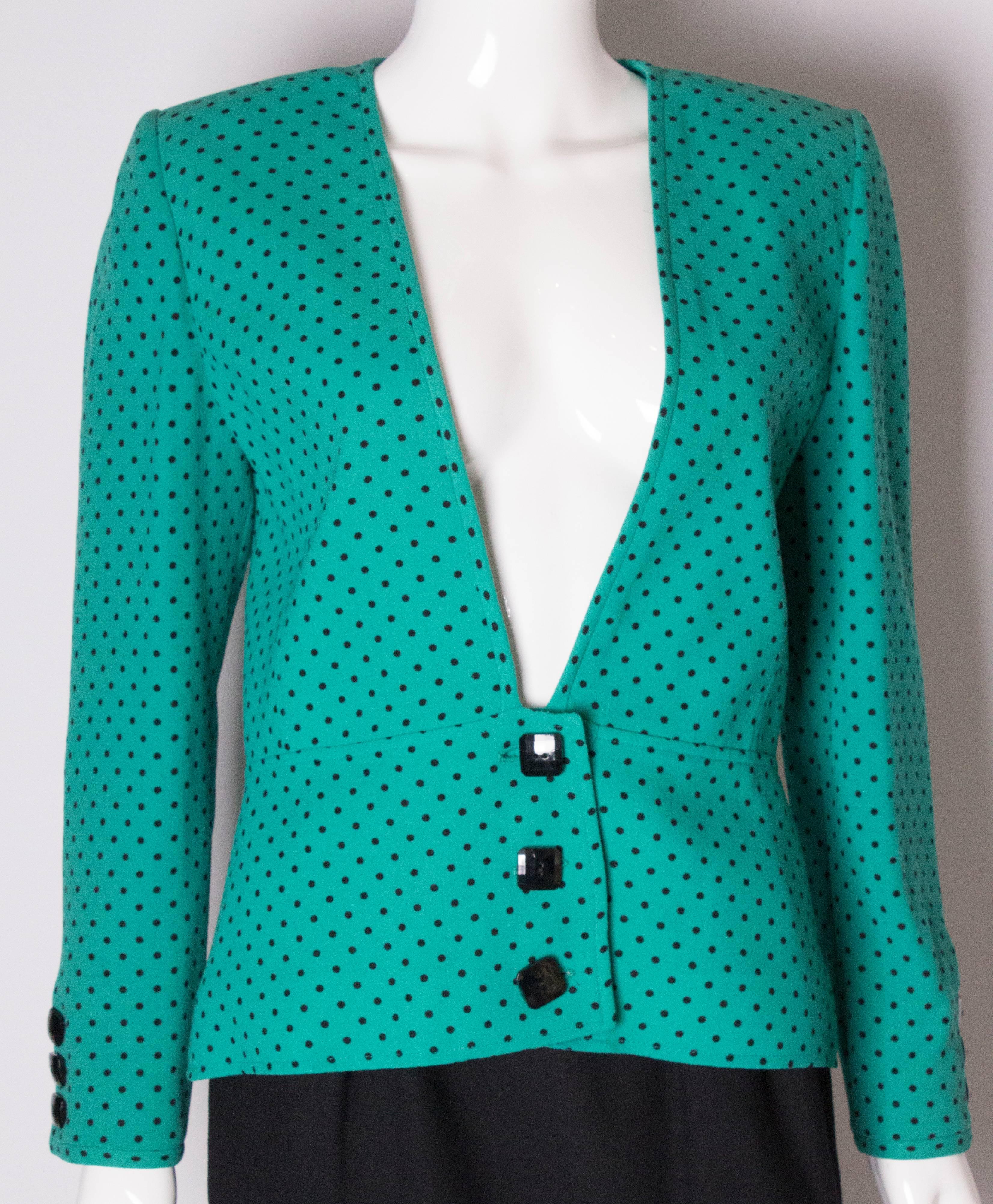An elegant green polka dot jacket by Valentino, Boutique line. The jacket is made of wool crepe and lined in silk. It has a v neckline and a three square button fastening at the bottom of the jacket. There are three buttons on each cuff, and