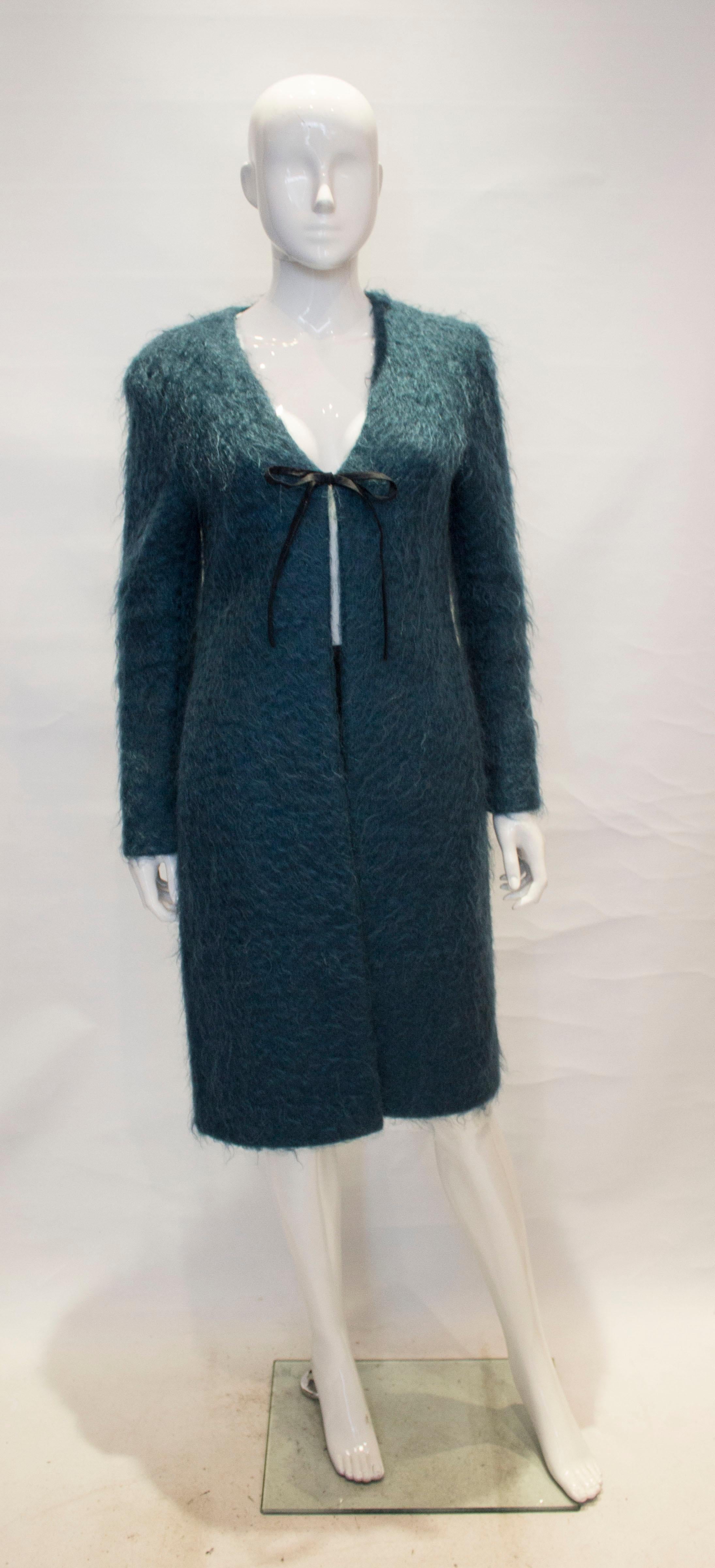 A chic and easy to wear vintage coat by Valention, Oliver line.  The coat is in a seagreen mohair  with ribbon tie fastening. It is fully lined, and has v neckline and pocket on either side.