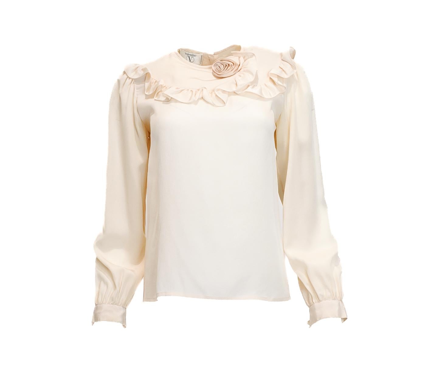 Esta blusa de seda Valentino Vintage, con un delicado cuello con volantes y un sutil detalle de rosas, ofrece una elegancia atemporal ideal para eventos diurnos o entornos profesionales. Su tono crema combina sin esfuerzo con una americana, lo que