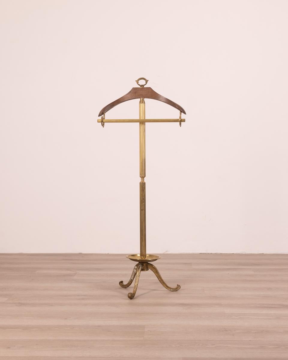 Valet stand with gilt brass structure and wooden hanger; has a small object holder in the lower part, 60s.

CONDITION: In good condition, it shows signs of wear caused by time.

DIMENSIONS: Height 106 cm; Width 44cm; Depth 32cm

MATERIALS: Brass and