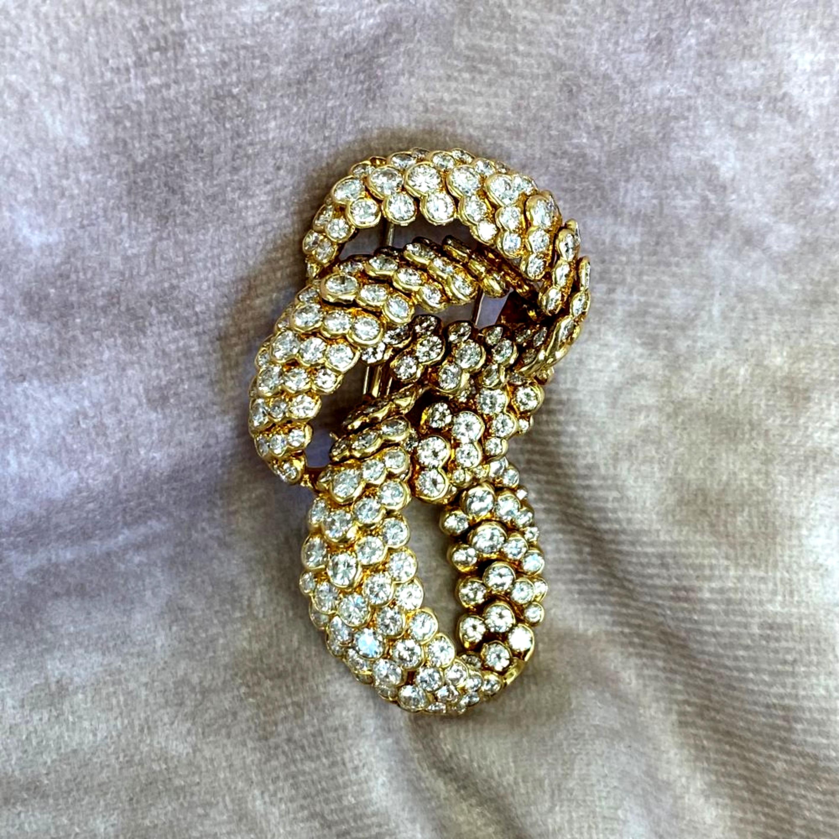 This is a beautiful vintage Van Cleef and Arpels brooch crafted in France circa 1960. It features three interlocking bands of 18k yellow gold adorned with graduated rows of collection-grade diamonds (11.20 carats total weight), set in half-bezels.