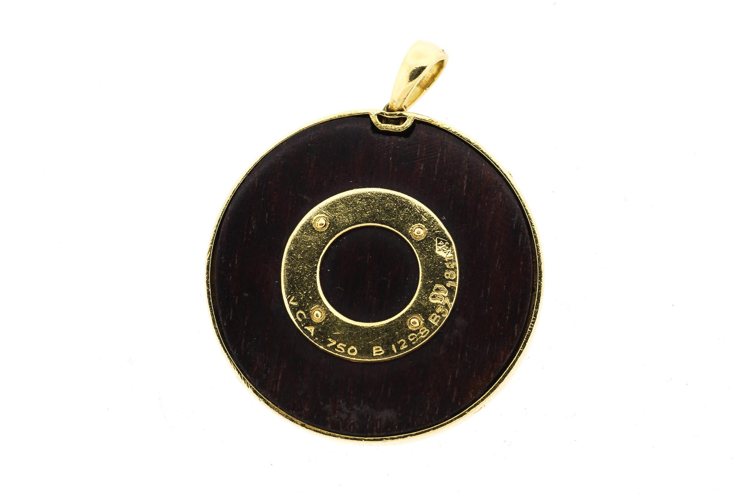 Vintage 18k yellow gold and wood clover pendant with the French saying, “Je Te Porterai Bonheur” written around the clover. It translates to “I will bring you luck.” A chic French charm made in gold and wood by Van Cleef & Arpels circa 1960. These