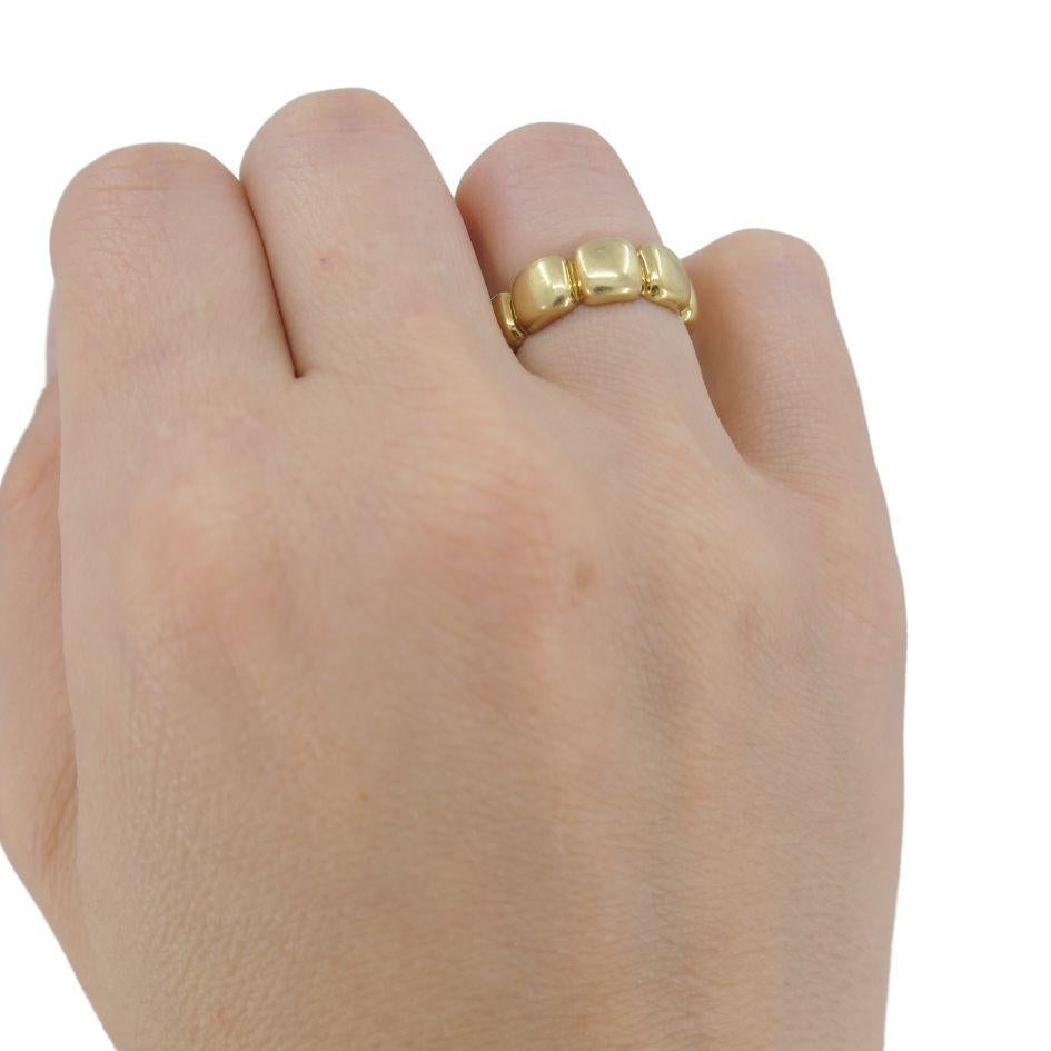 This Van Cleef & Arpels 18k yellow gold band ring features a scalloped, pillowy design that creates a softly contoured silhouette around the finger. Crafted with signature precision, the repeating gold segments are smooth and substantial, offering a